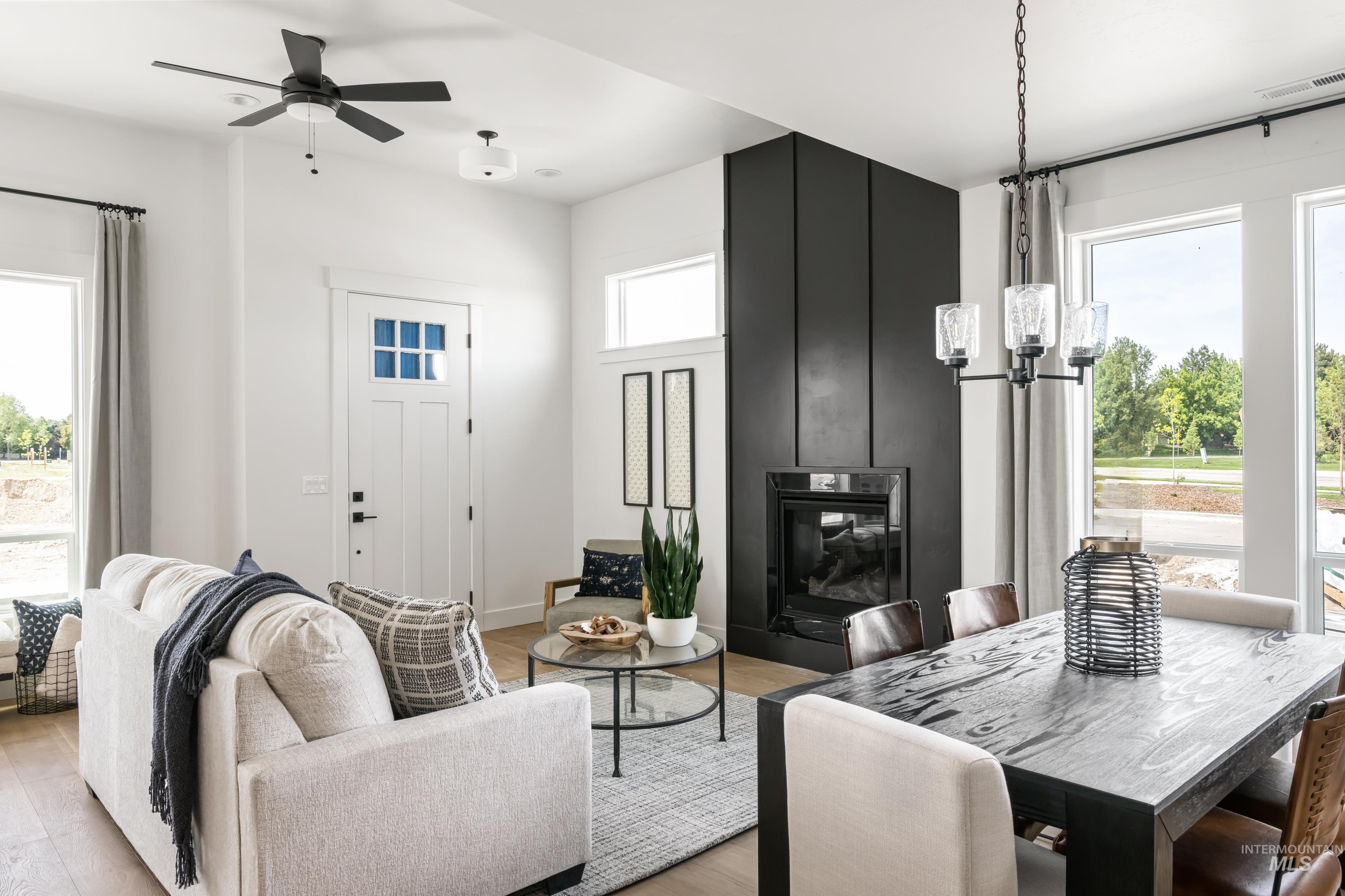 Dining room featuring plenty of natural light, a fireplace, light wood finished floors, and a chandelier