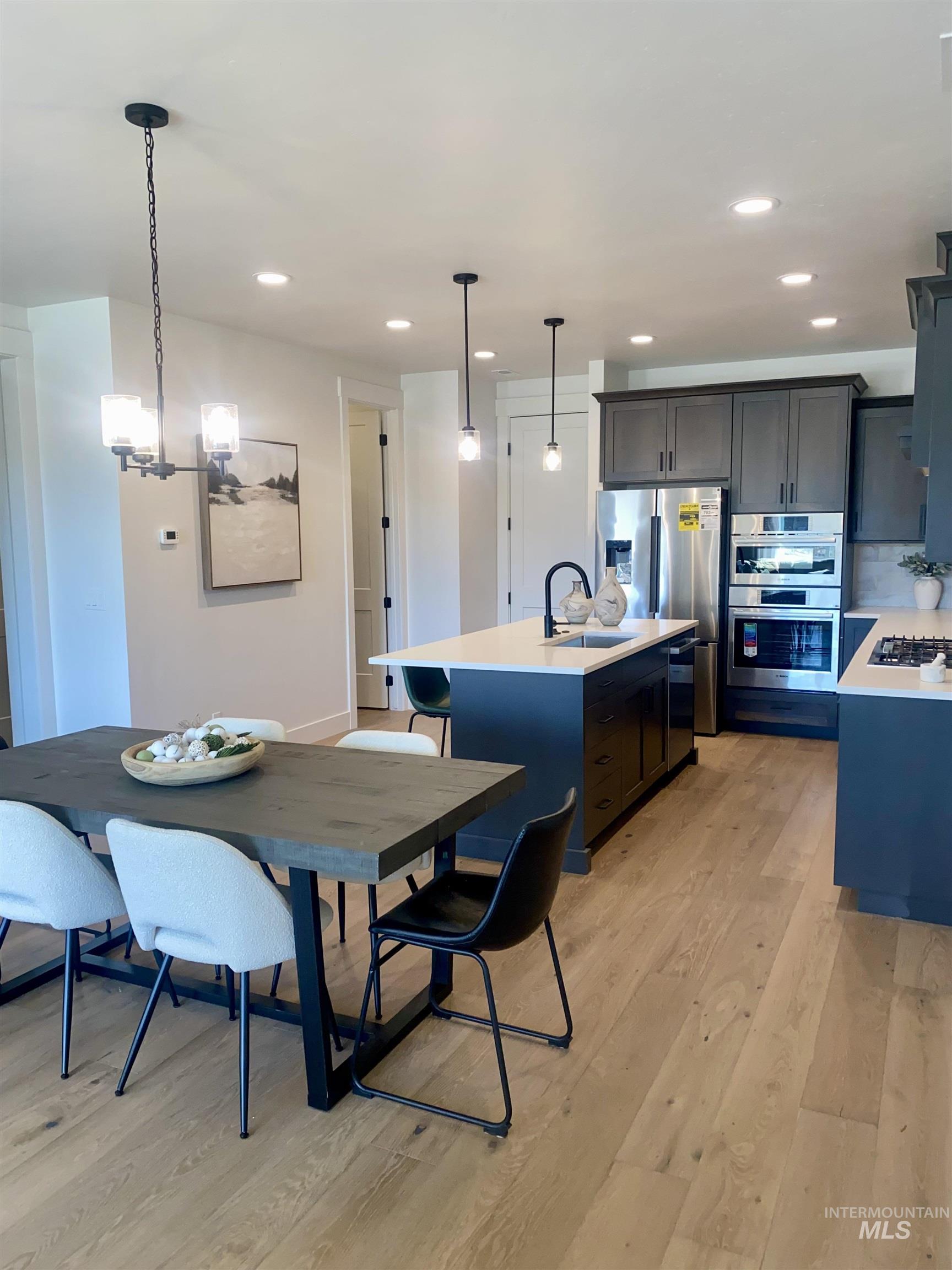 Dining room with light wood finished floors, recessed lighting, and a chandelier