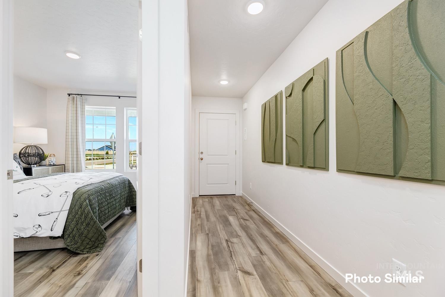 Hallway with light wood-style flooring and recessed lighting