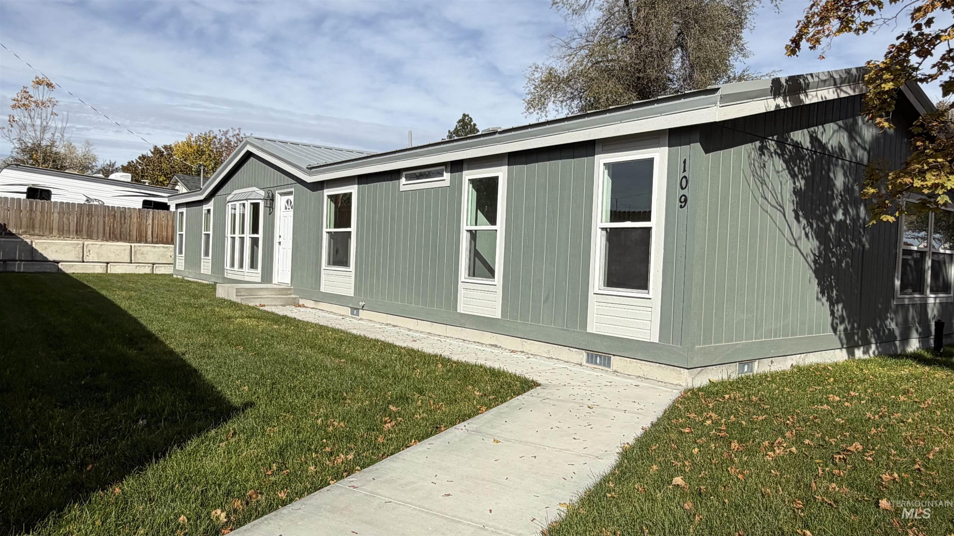 View of home's exterior with entry steps and a metal roof