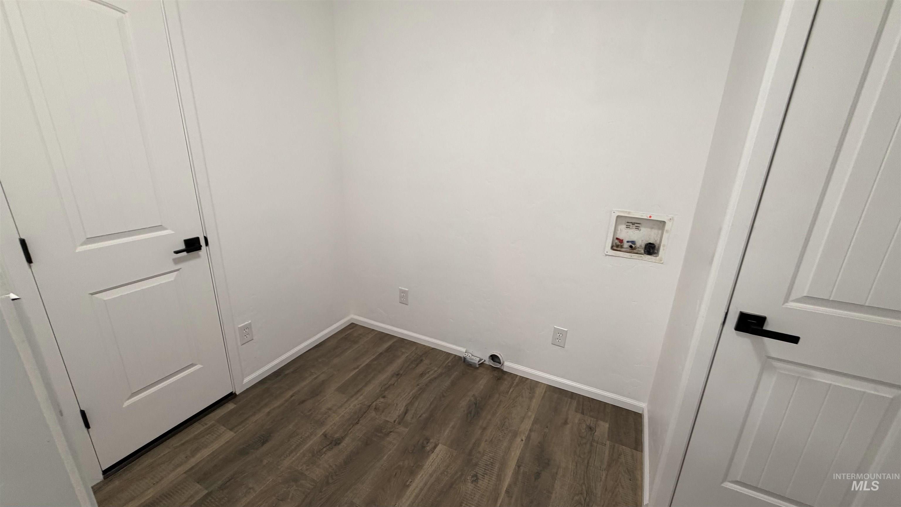 Laundry room with dark wood-style flooring and hookup for a washing machine
