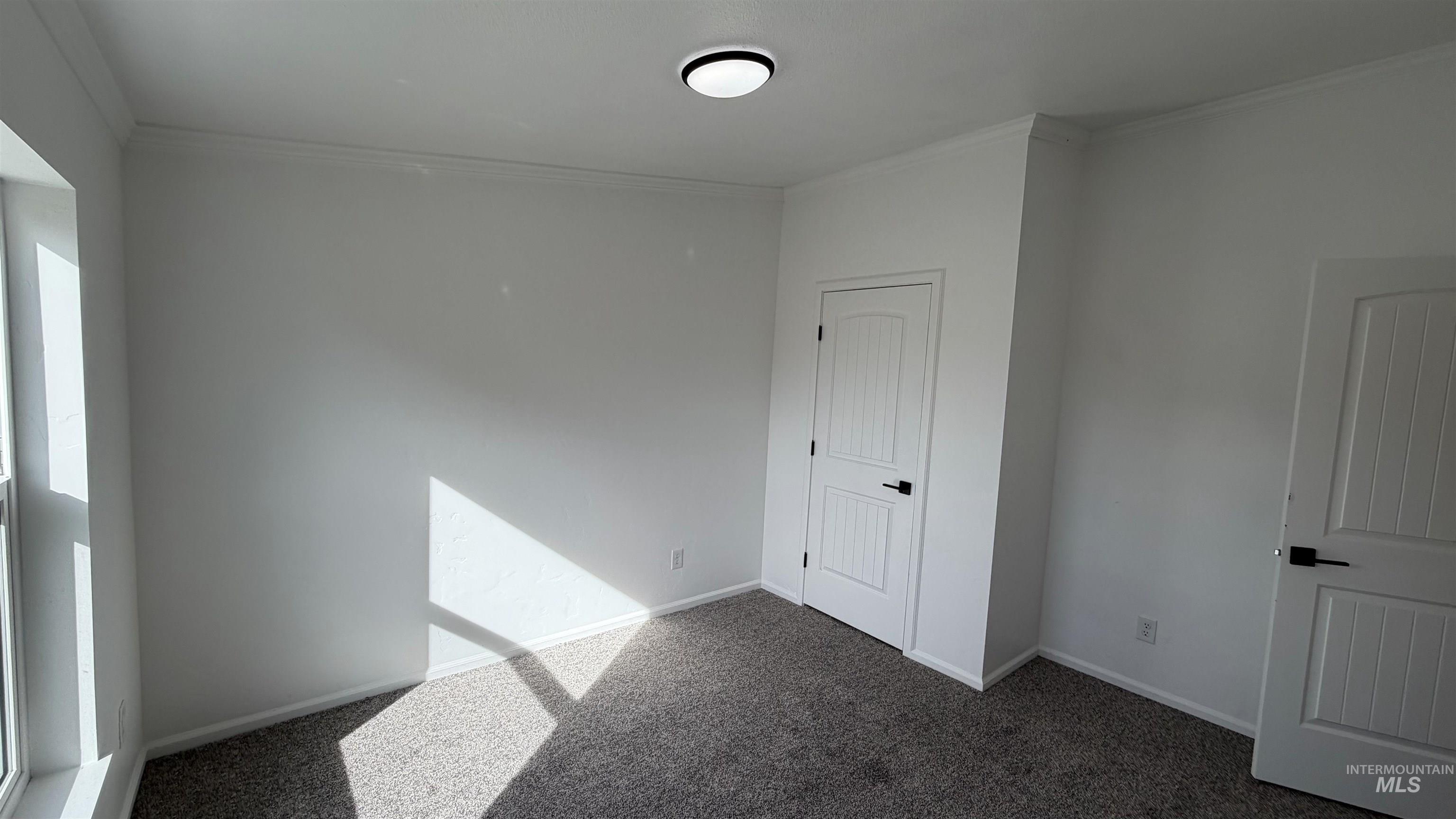 Unfurnished bedroom featuring dark colored carpet and ornamentahttps://imls.paragonrels.com/ParagonLS/Scripts/autocompletefb/delete.gifl molding