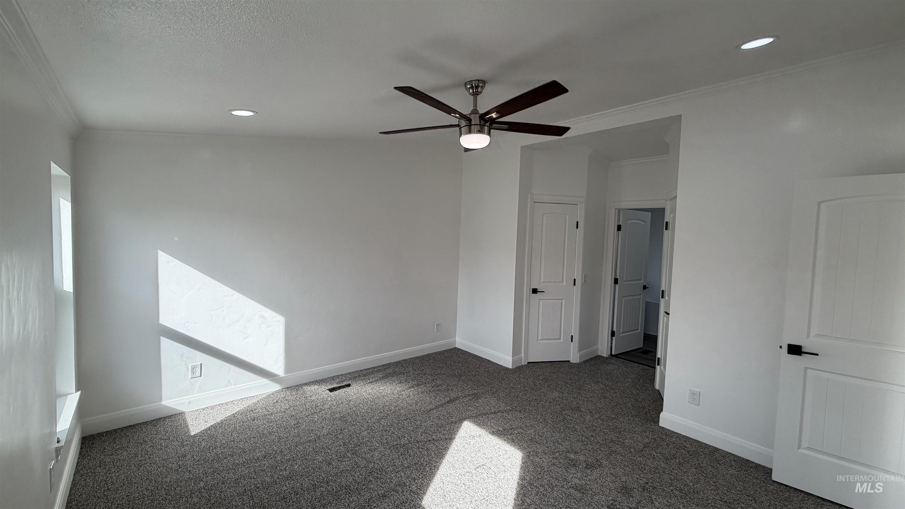Unfurnished bedroom with crown molding, carpet flooring, a ceiling fan, and recessed lighting