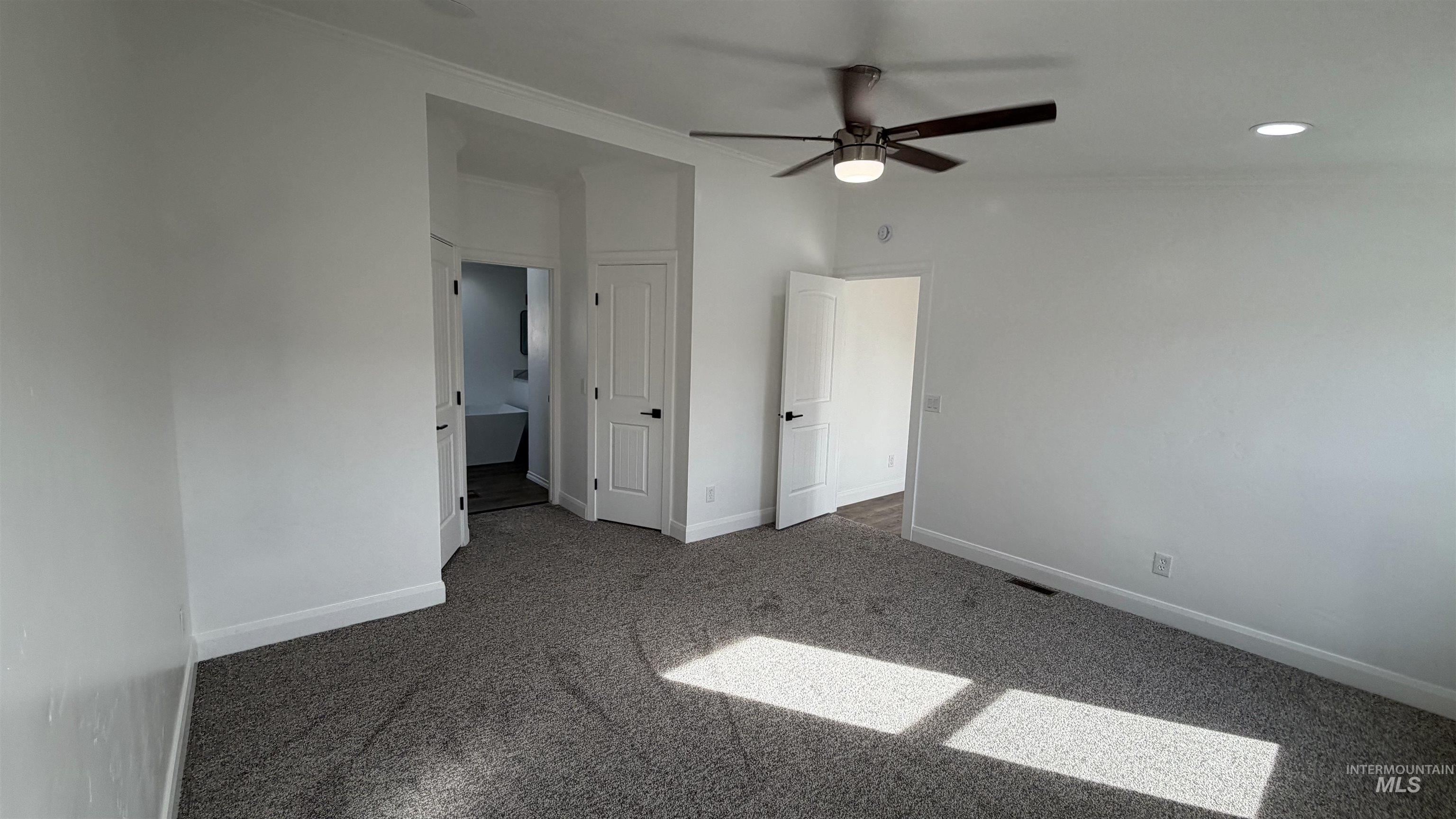 Unfurnished bedroom with carpet floors, ensuite bath, a ceiling fan, recessed lighting, and ornamental molding