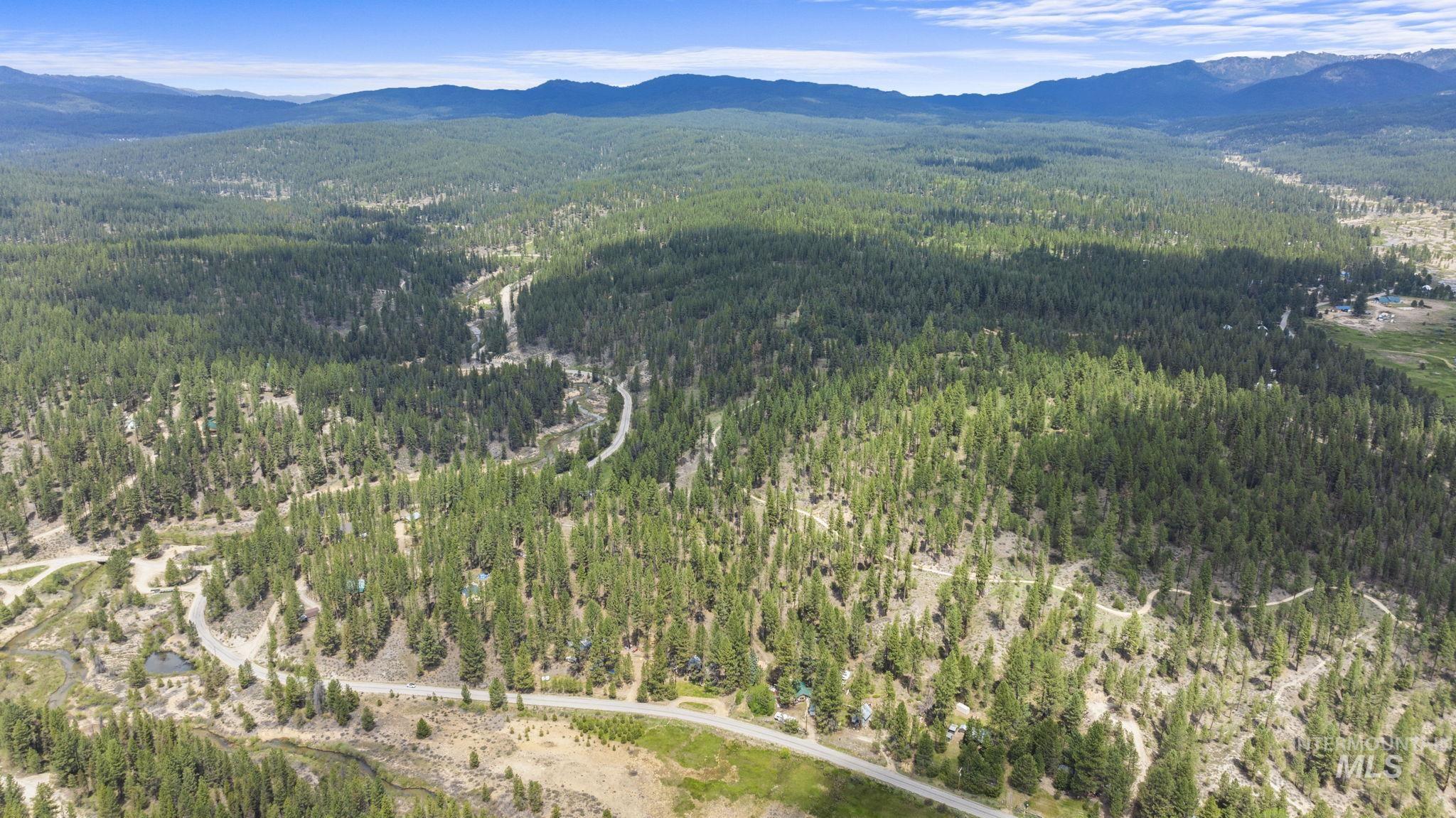 View of property location with a mountain backdrop and a forest
