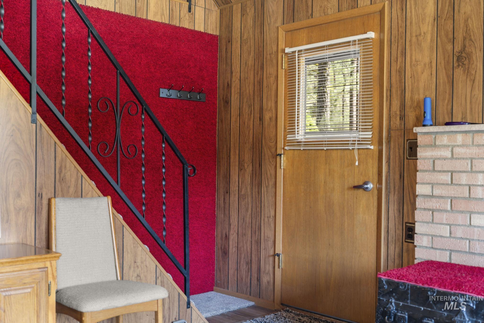 Foyer entrance with wood walls and stairs