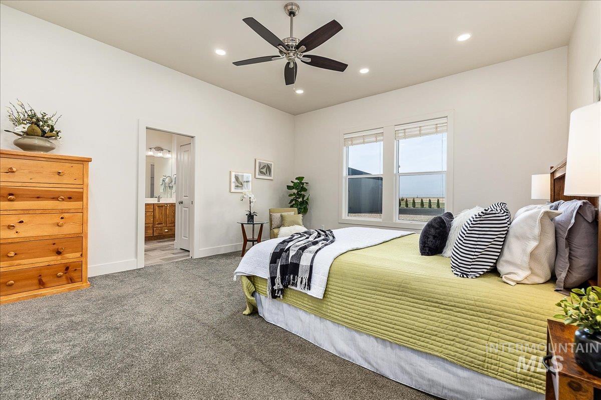 Carpeted bedroom featuring recessed lighting, ensuite bath, and a ceiling fan