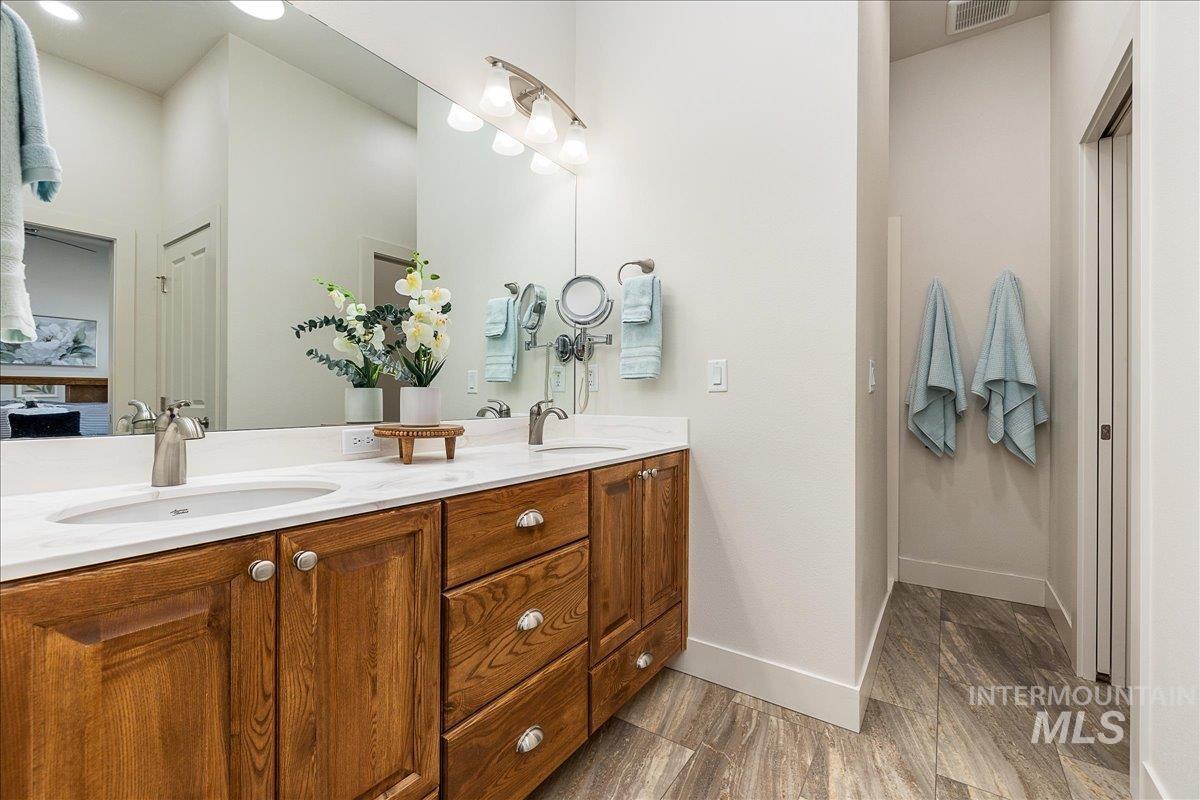 Bathroom with double vanity, walk-in shower, linen closet, toilet room, and walk-in closet
