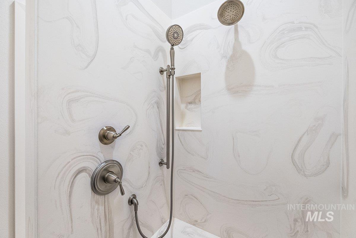 View of the marble finish shower with bench and niche