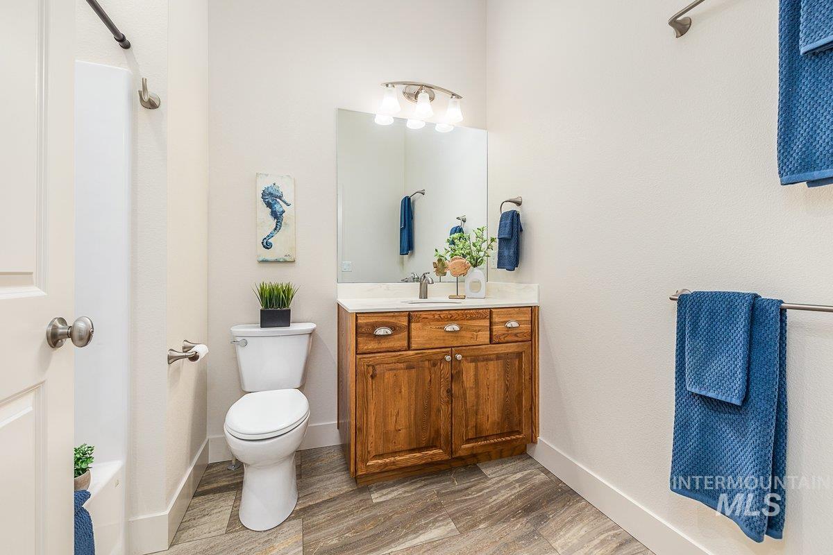 Full bathroom featuring vanity, dark wood-style flooring, and a shower