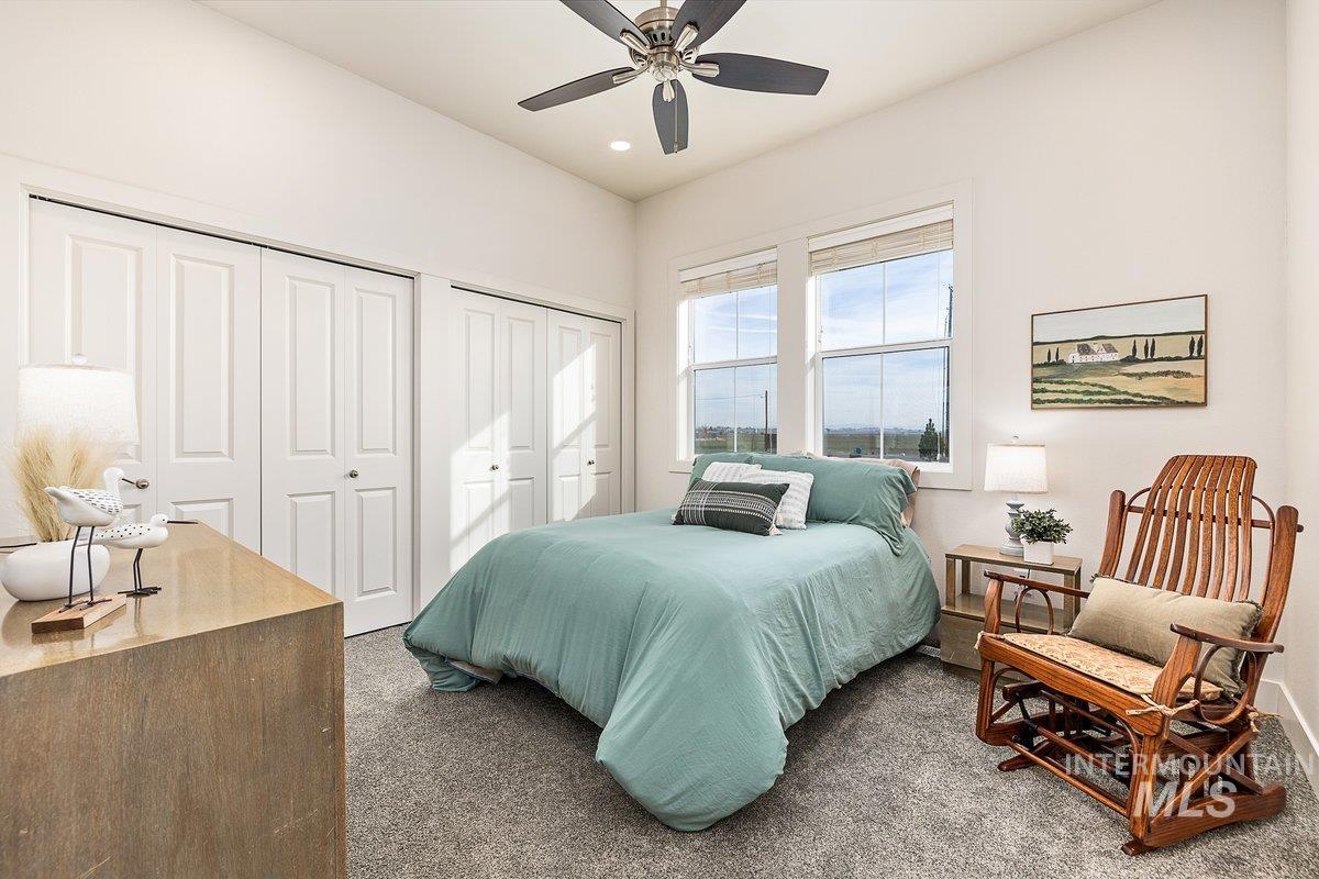 Bedroom with carpet, two closets, ceiling fan, and recessed lighting