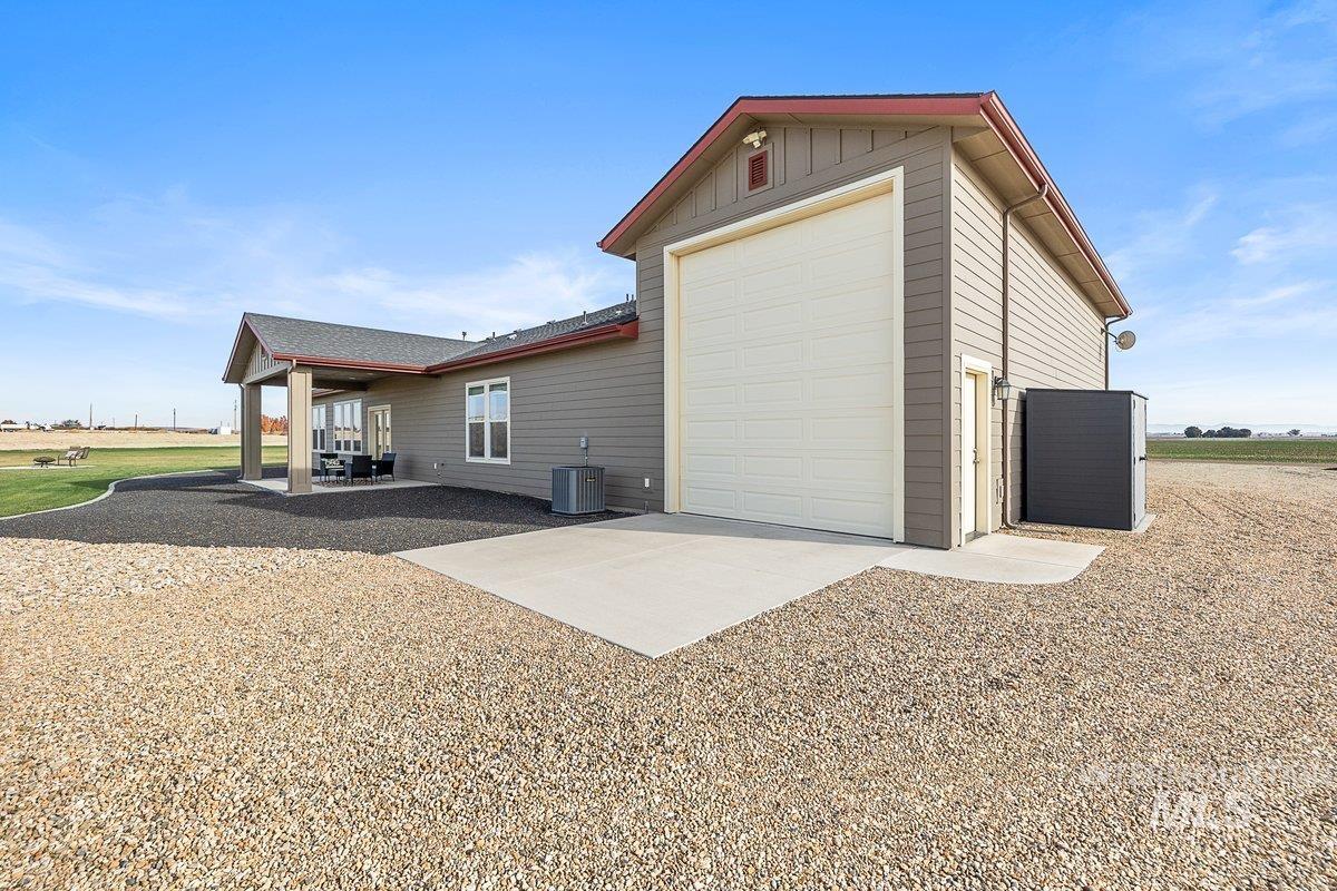 View of property exterior featuring a patio area, shed, and RV garage