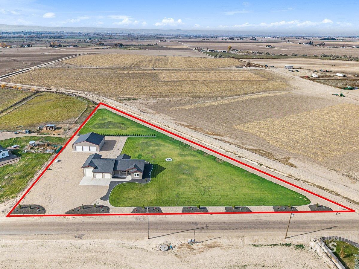 Aerial view of sparsely populated area featuring property parcel outlined