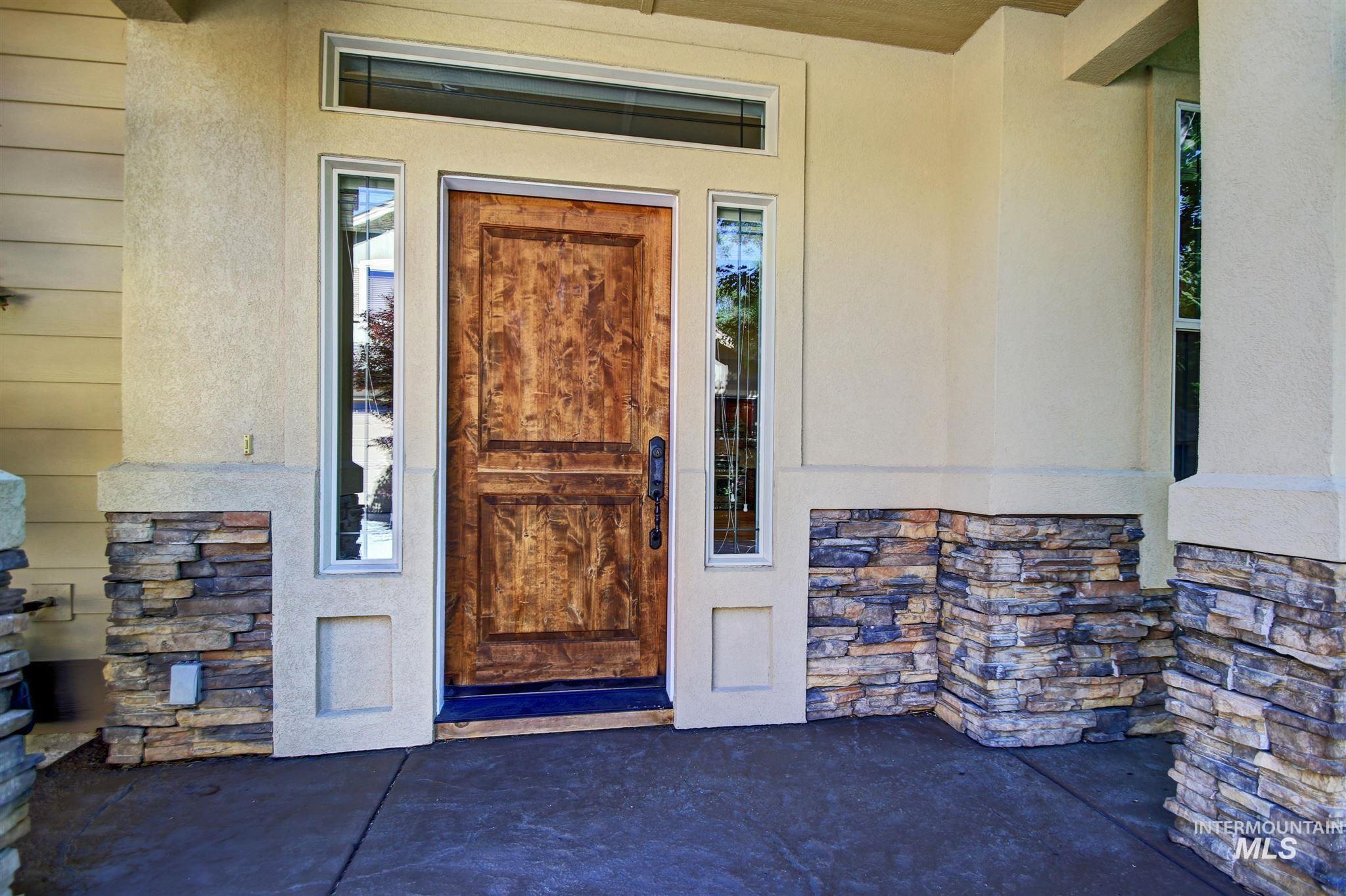 Property entrance with stone siding and stucco siding
