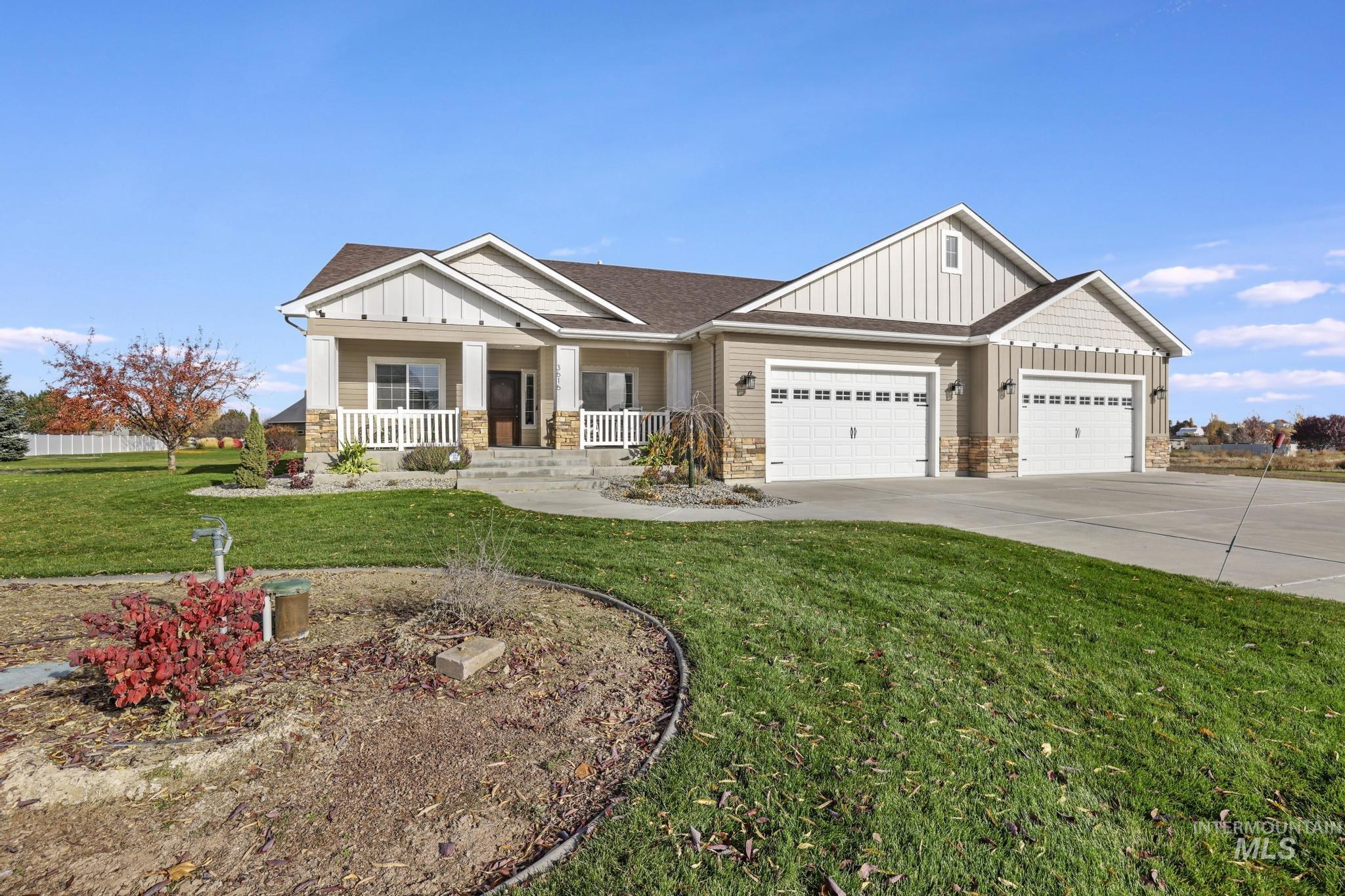 Craftsman-style house featuring board and batten siding, stone siding, a front yard, and a porch