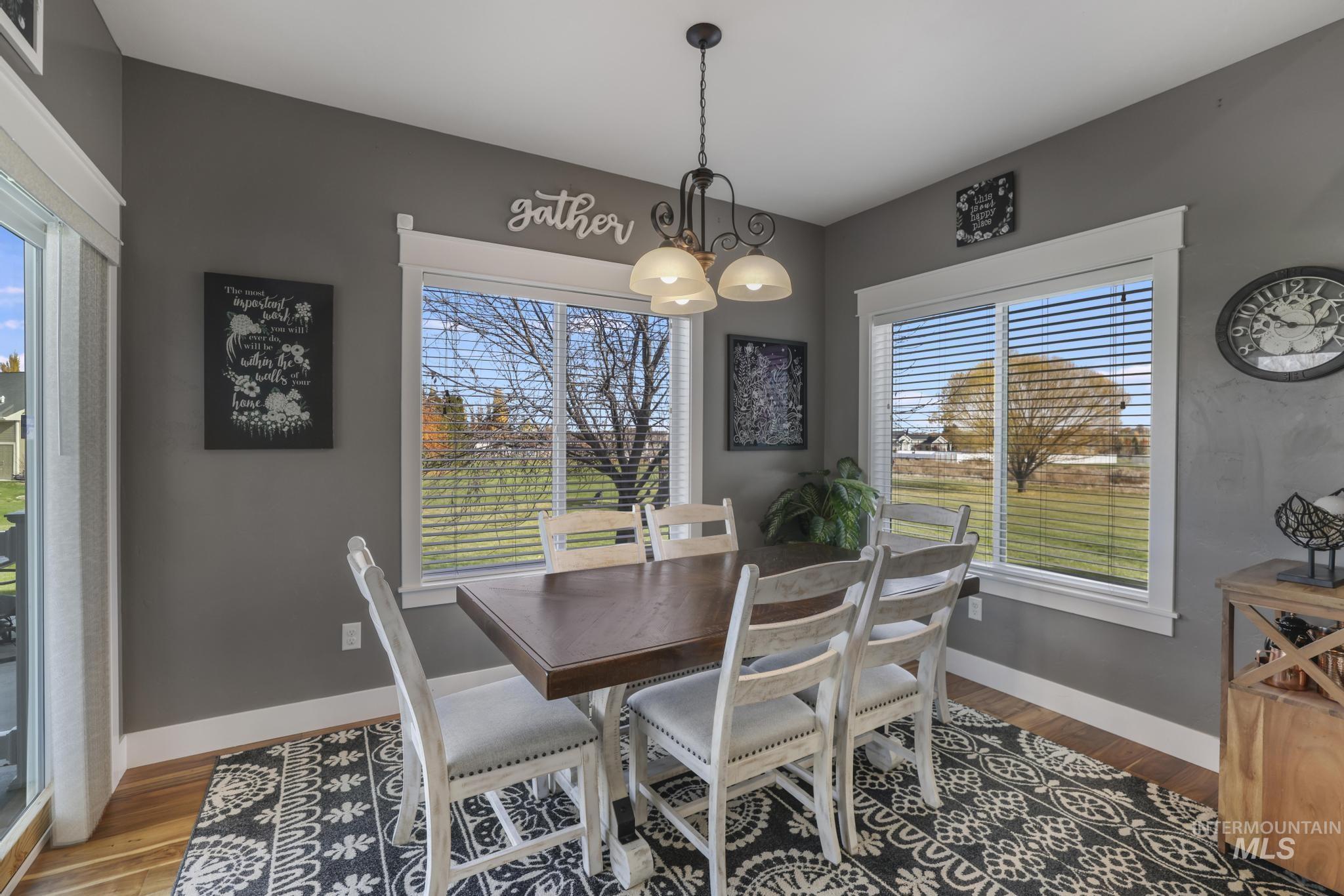 Dining room with wood finished floors and a chandelier