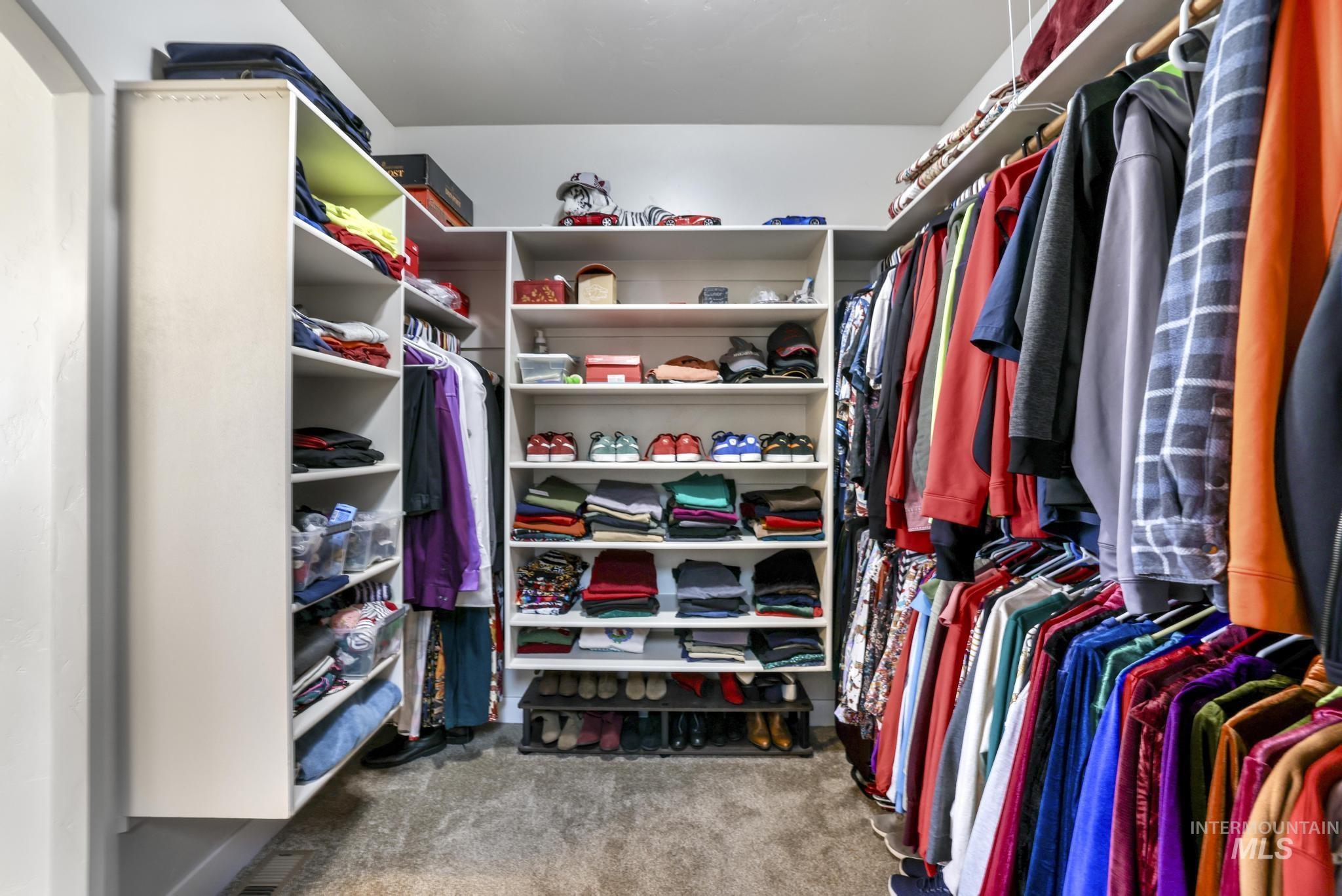 Spacious closet featuring light colored carpet