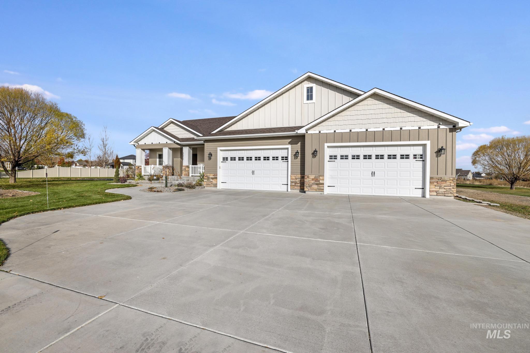 Craftsman house featuring board and batten siding, stone siding, driveway, and an attached garage