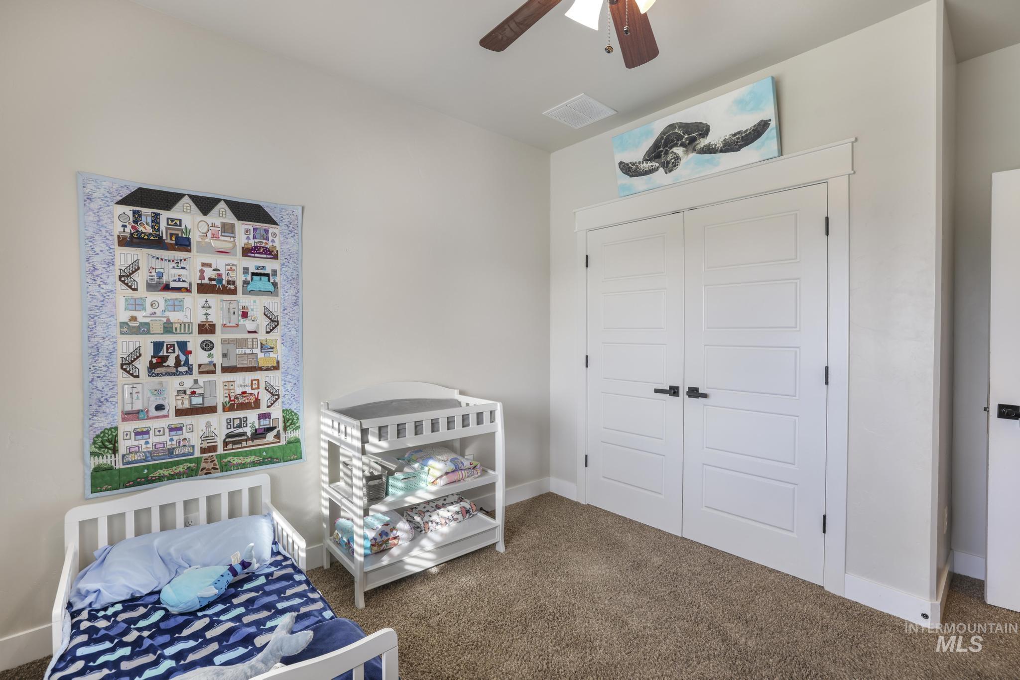 Carpeted bedroom with a closet and ceiling fan