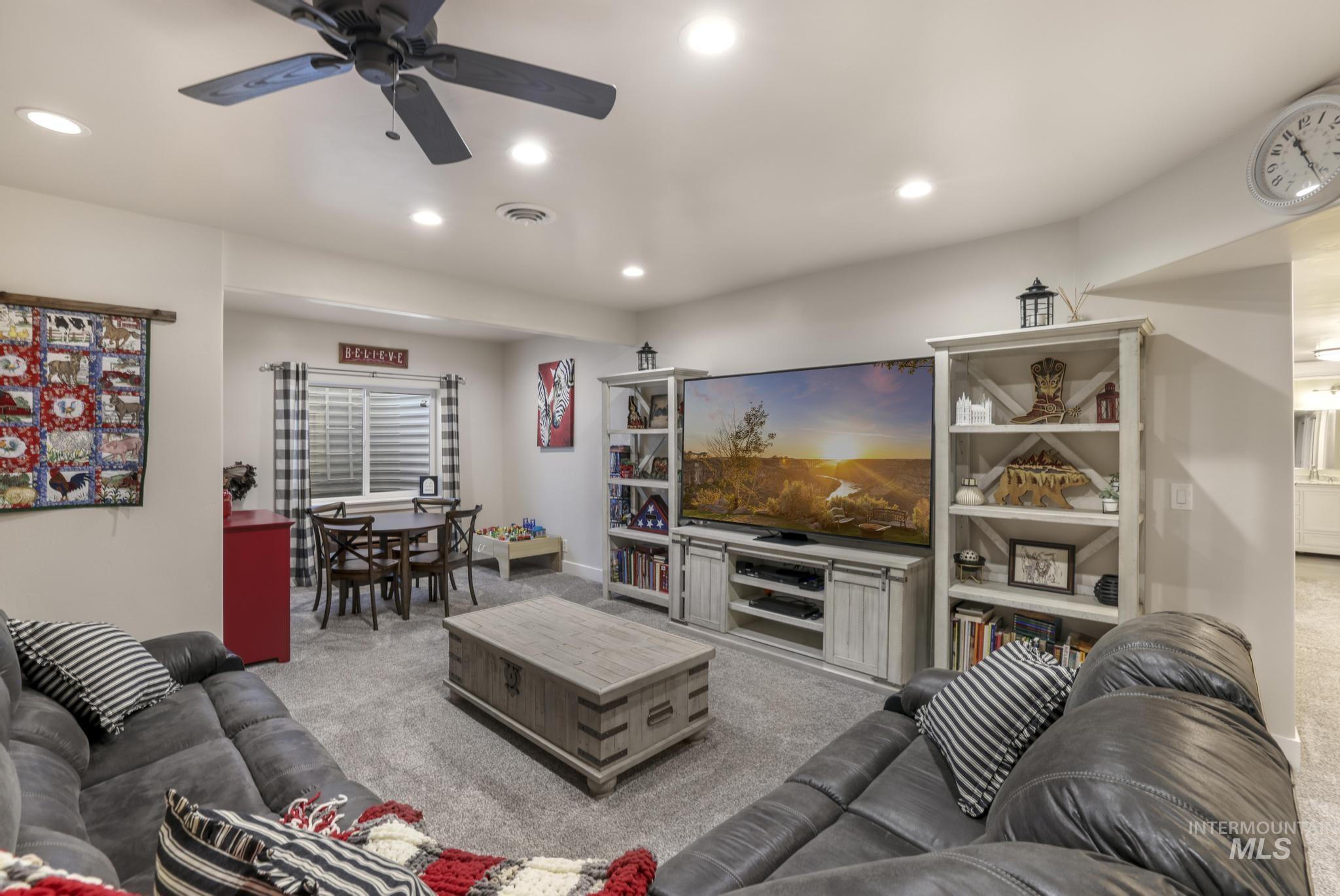Living room with light colored carpet, recessed lighting, and a ceiling fan