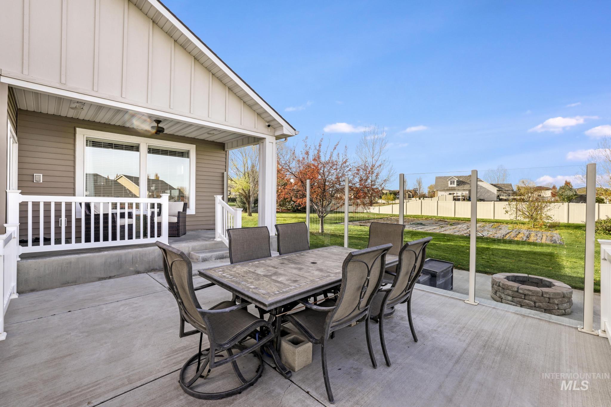 View of patio featuring outdoor dining area, an outdoor fire pit, and ceiling fan