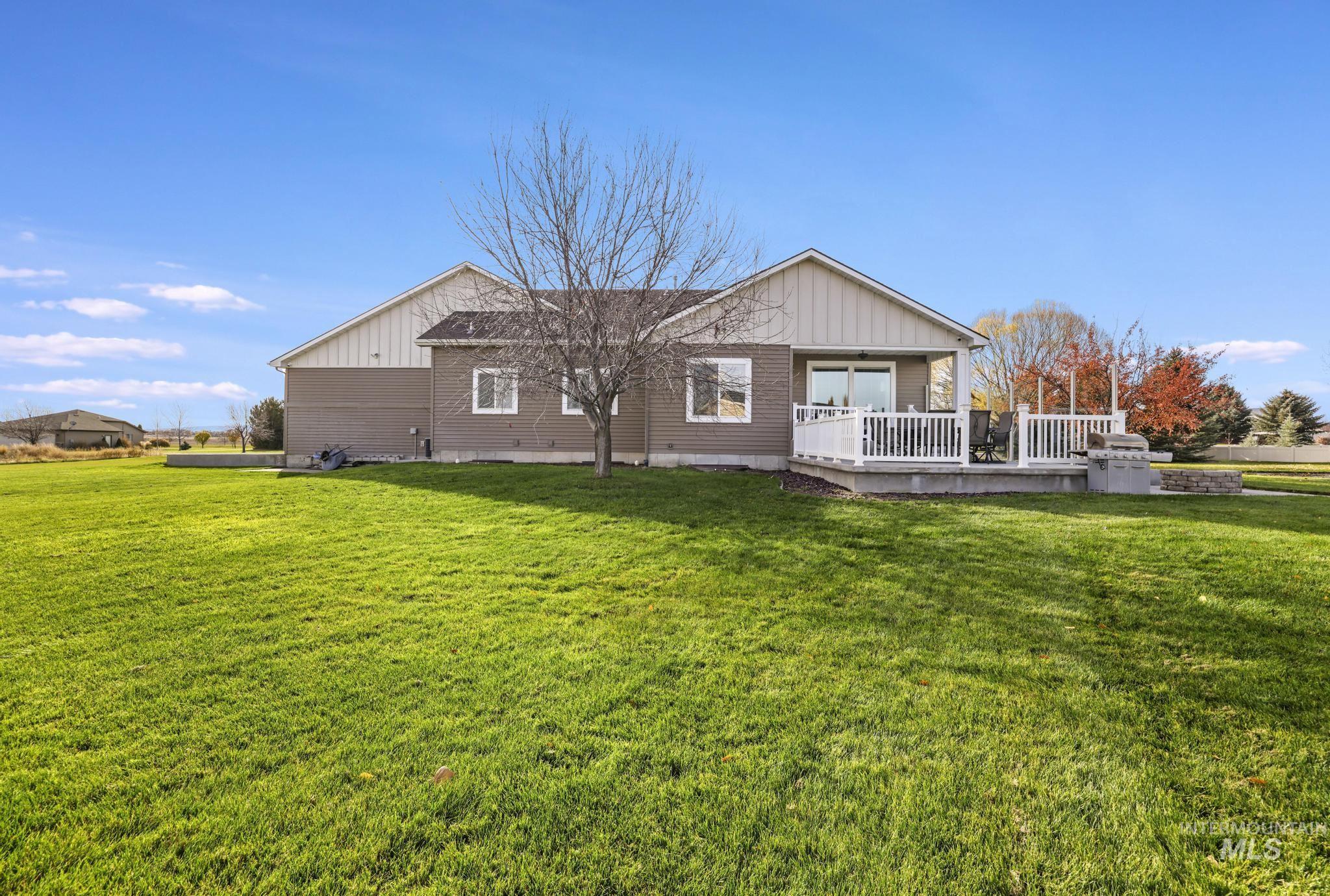 Back of house featuring a wooden deck, board and batten siding, and a lawn