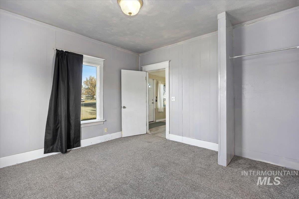 Unfurnished bedroom featuring ornamental molding, carpet floors, and a textured ceiling