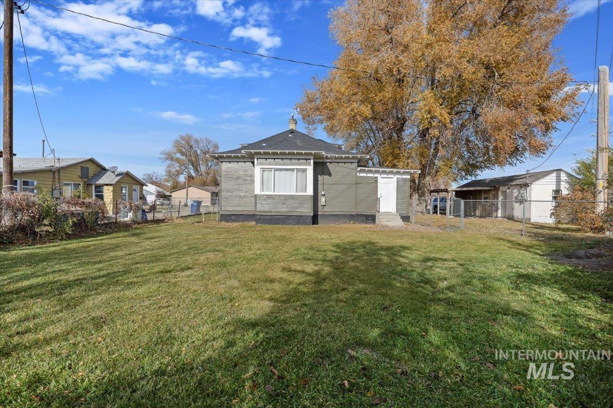 Back of property with a fenced backyard and a chimney