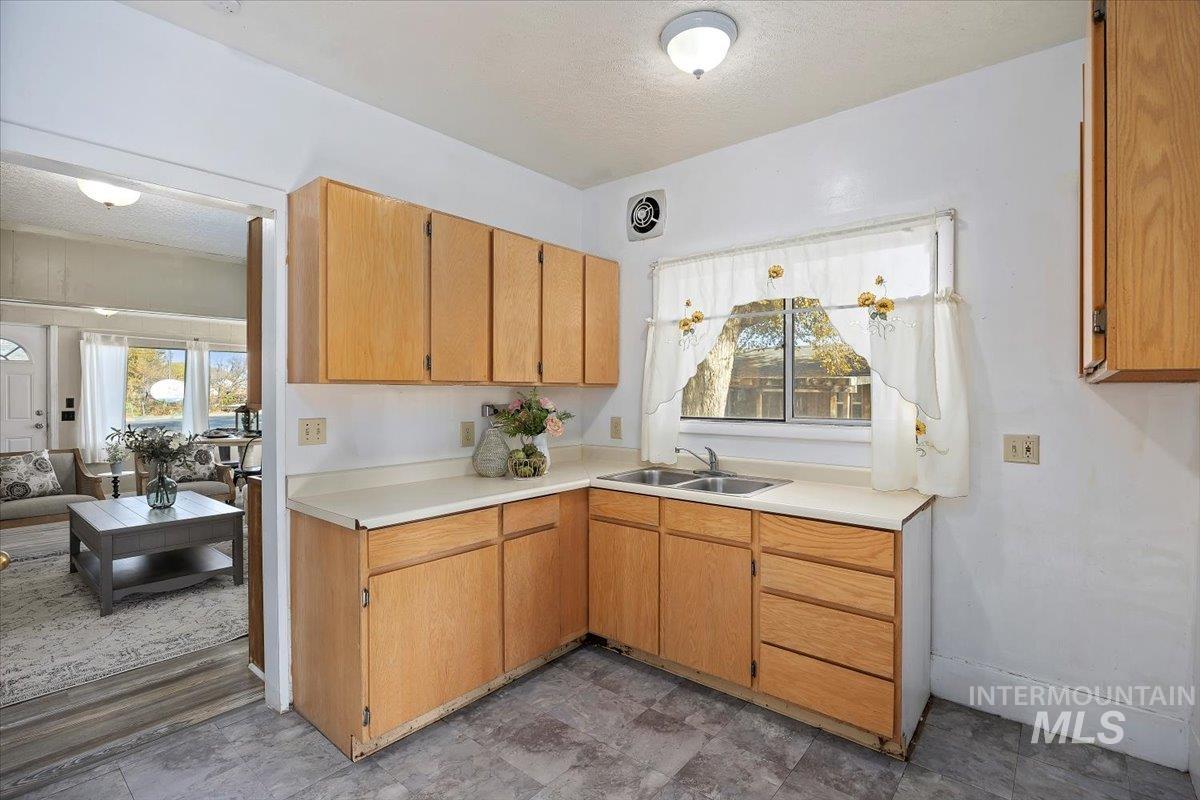 Kitchen with light countertops, a textured ceiling, and open floor plan