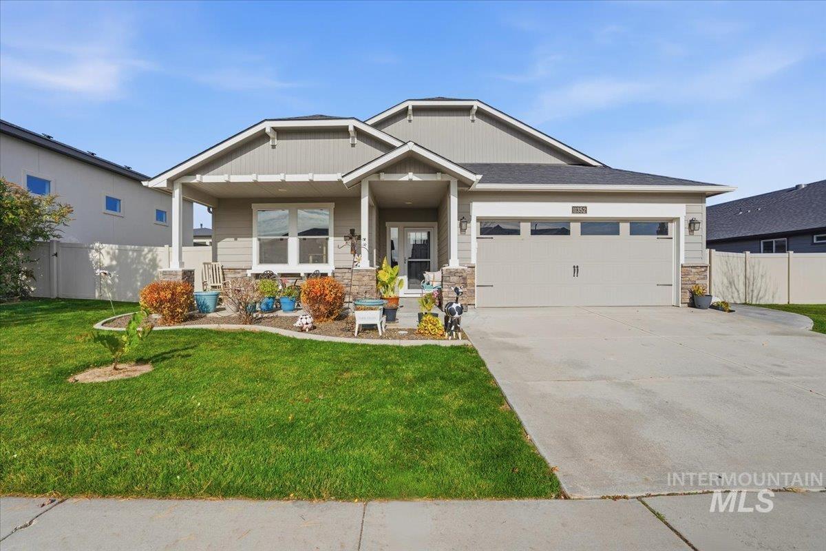 Craftsman-style house with stone siding, a porch, concrete driveway, and a garage