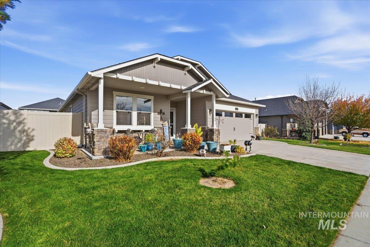 Craftsman house featuring concrete driveway, stone siding, covered porch, and an attached garage