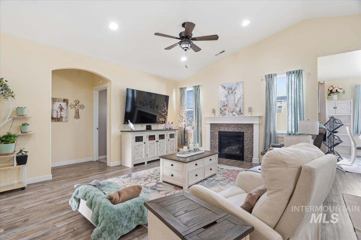 Living room featuring plenty of natural light, recessed lighting, light wood finished floors, ceiling fan, and arched walkways