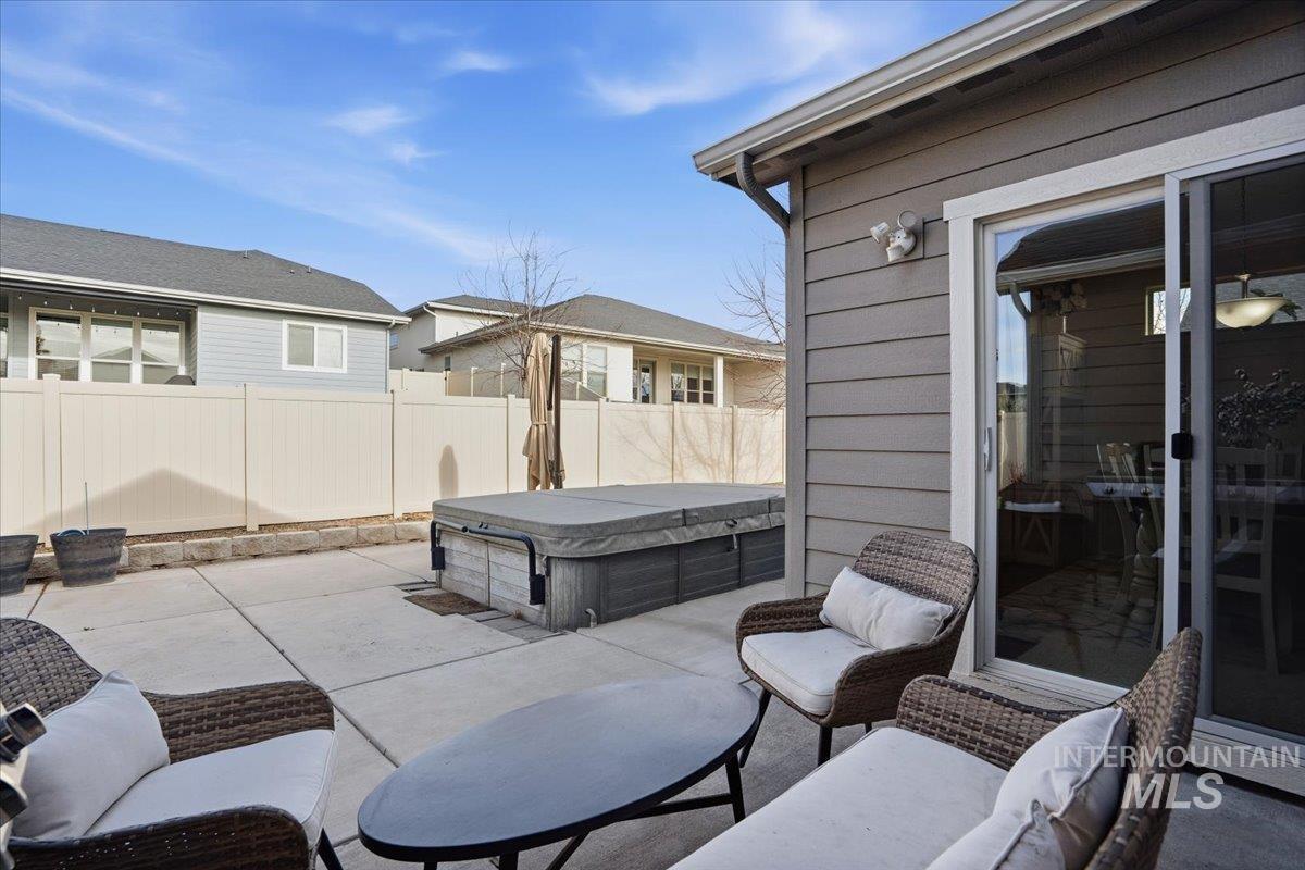 Fenced backyard with a patio and a hot tub