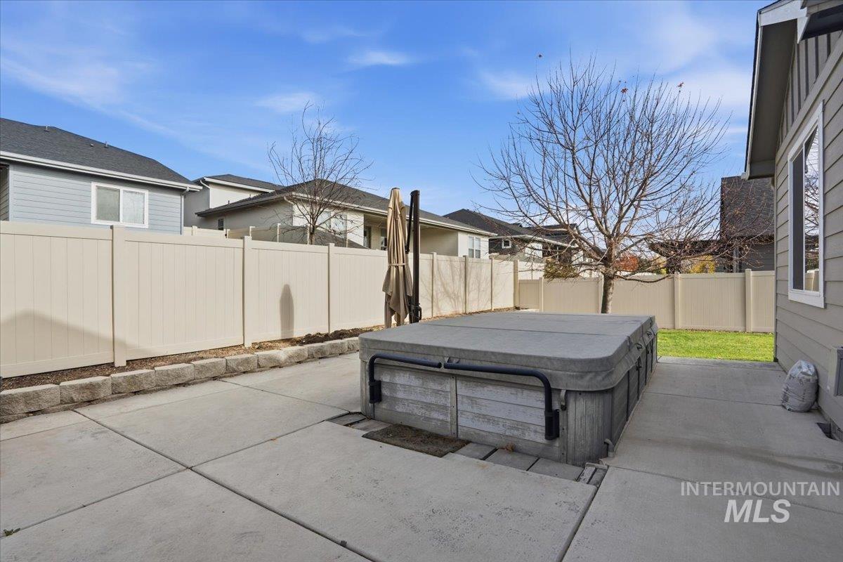 Fenced backyard with a patio and a hot tub