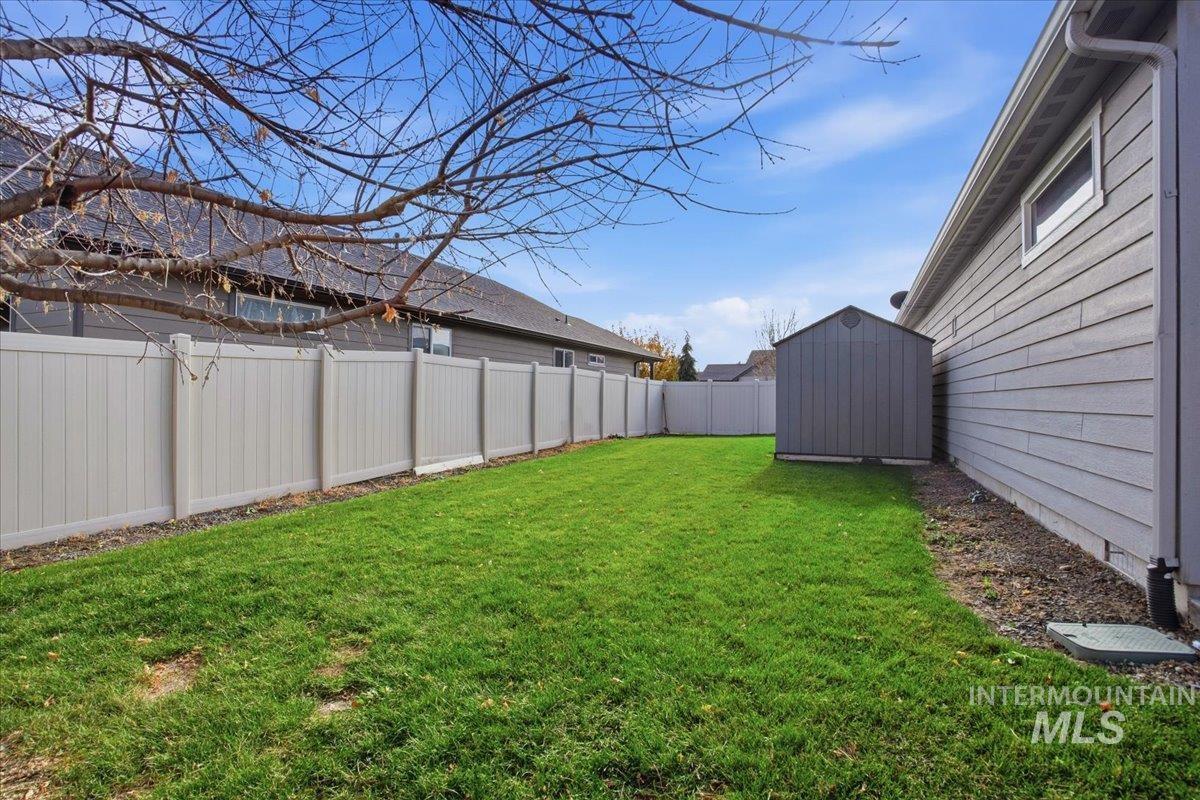 Fenced backyard with a storage unit