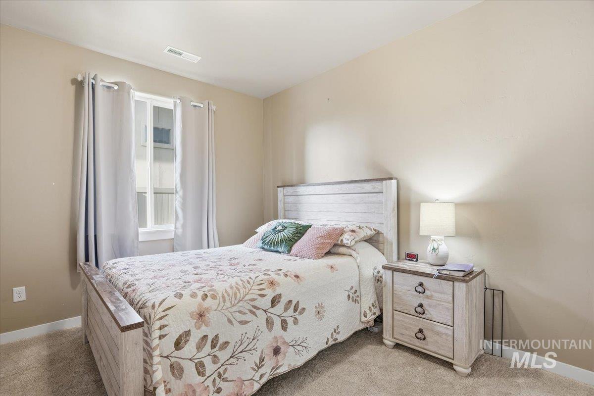 Bedroom featuring baseboards and light colored carpet