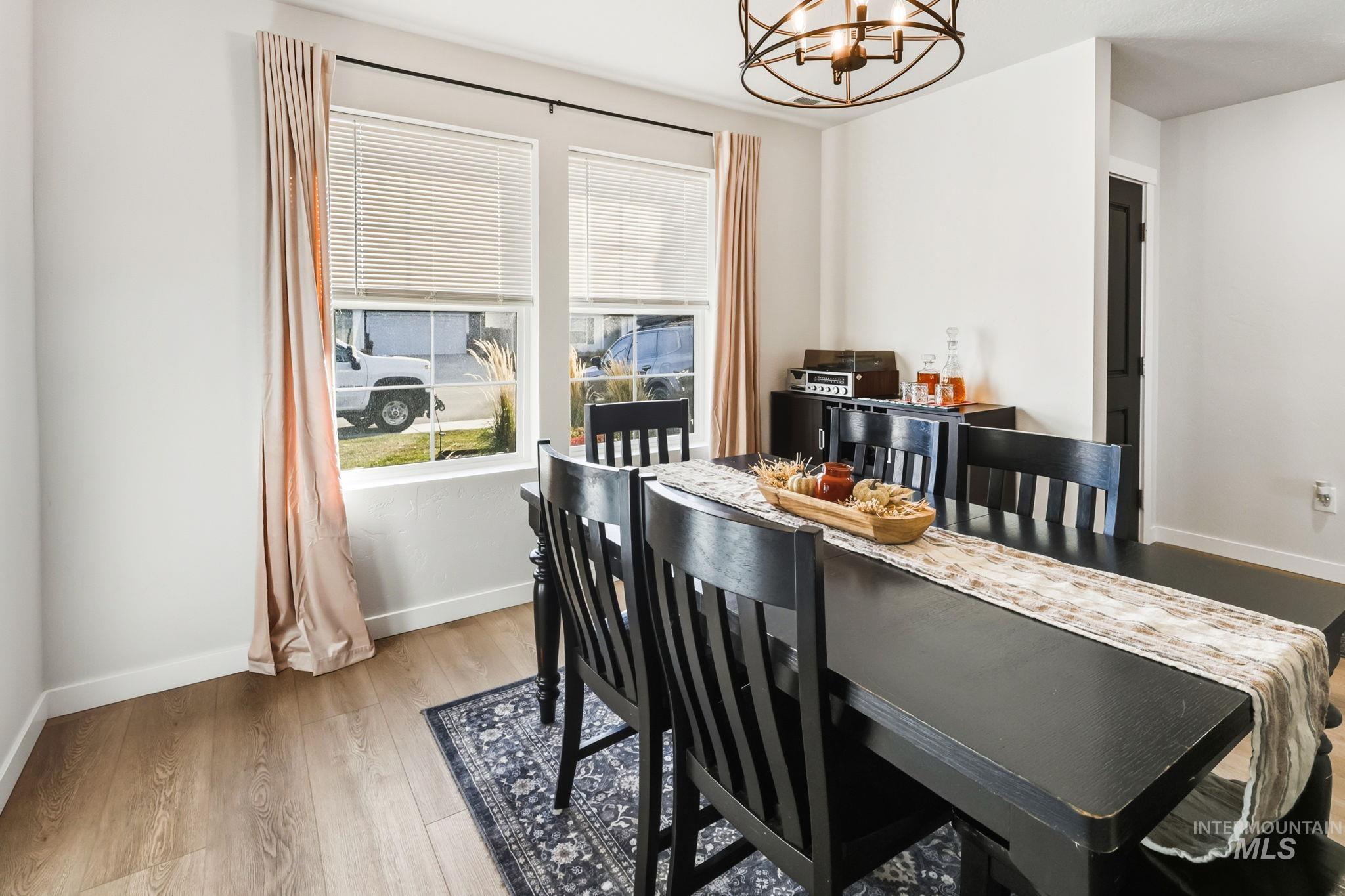 Dining room with plenty of natural light, light wood-type flooring, and a chandelier