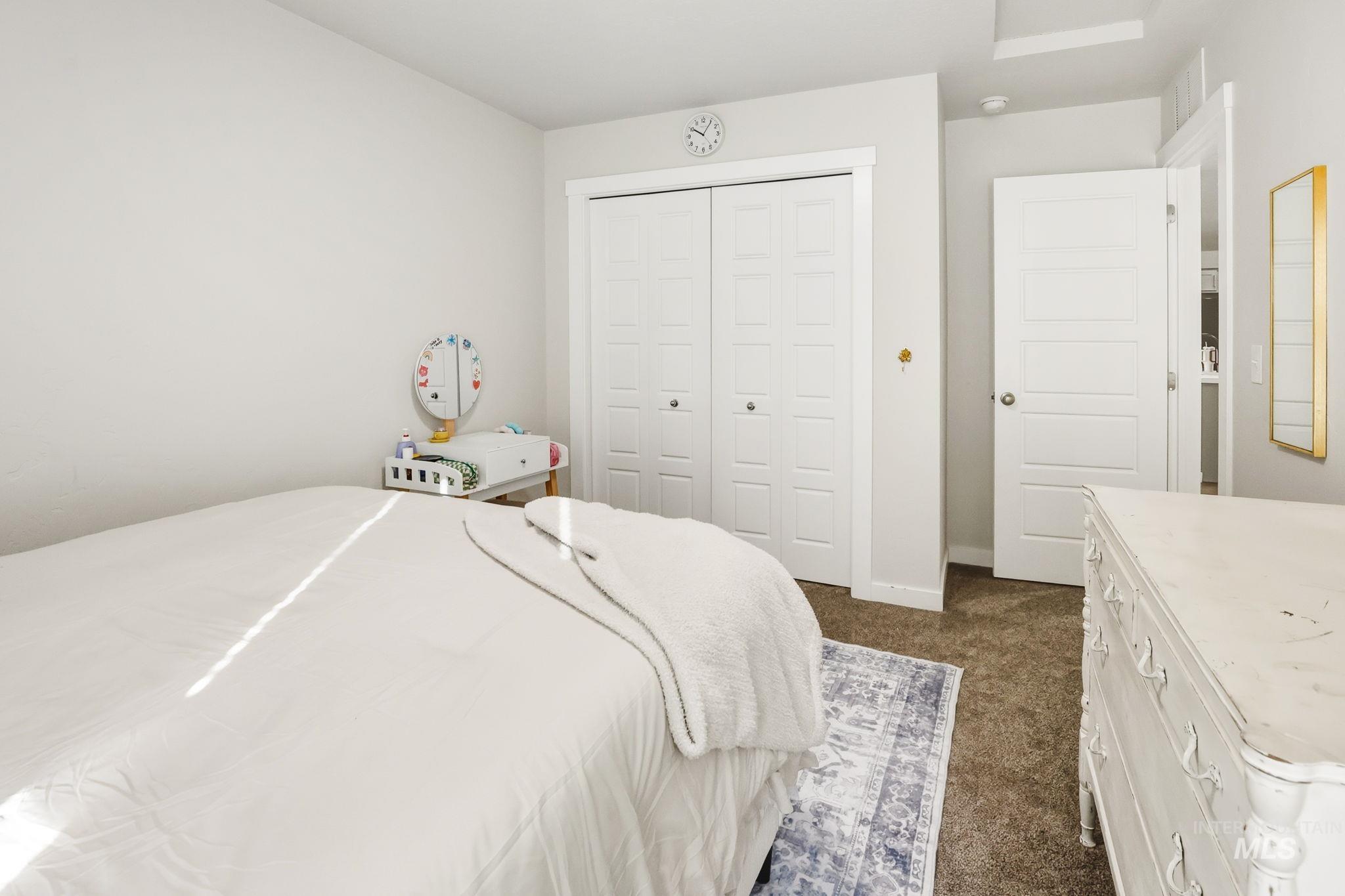 Bedroom with dark colored carpet and a closet