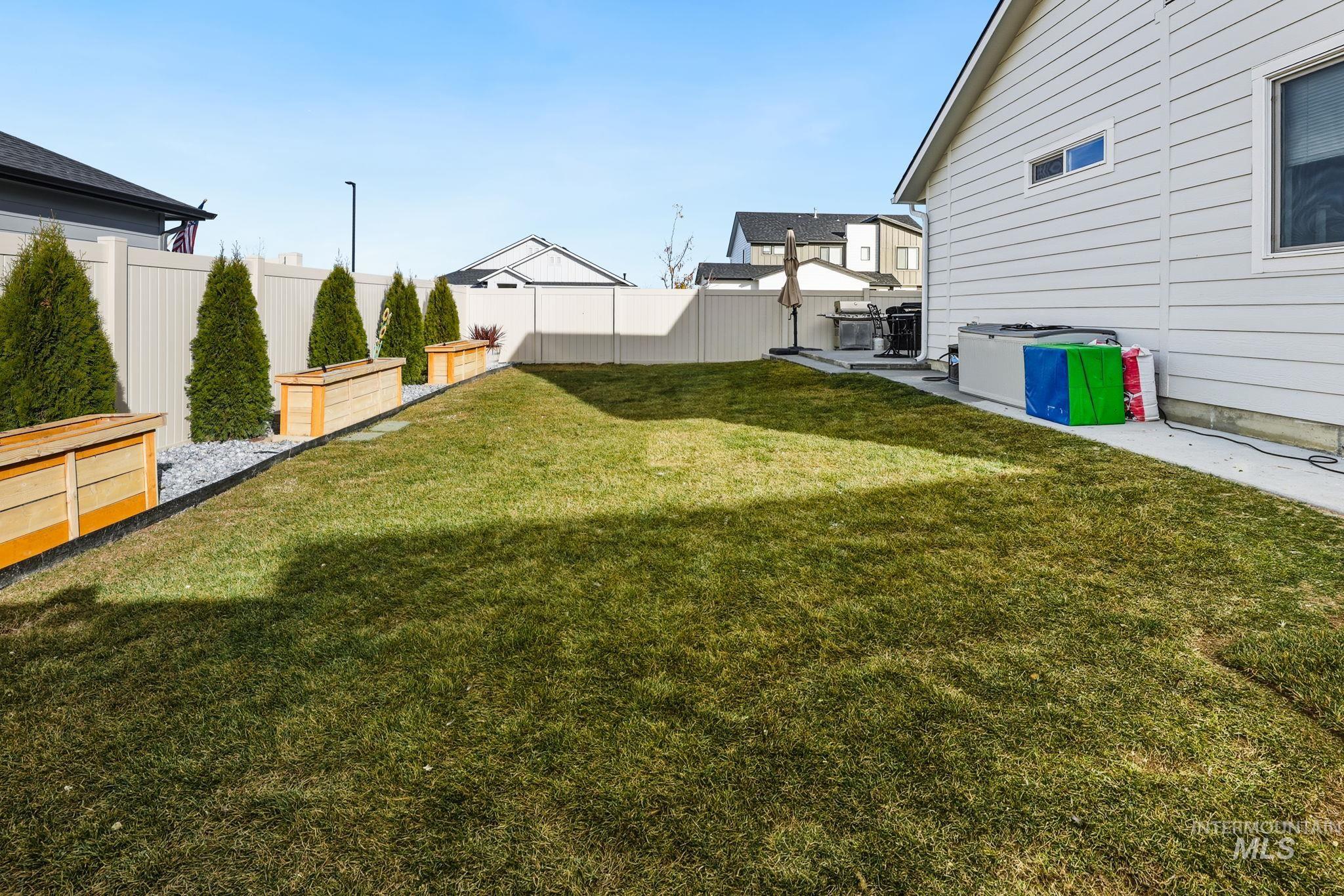Fenced backyard featuring a patio and a garden