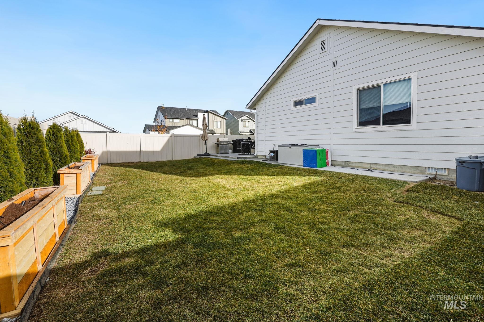 View of yard featuring a patio area and a vegetable garden