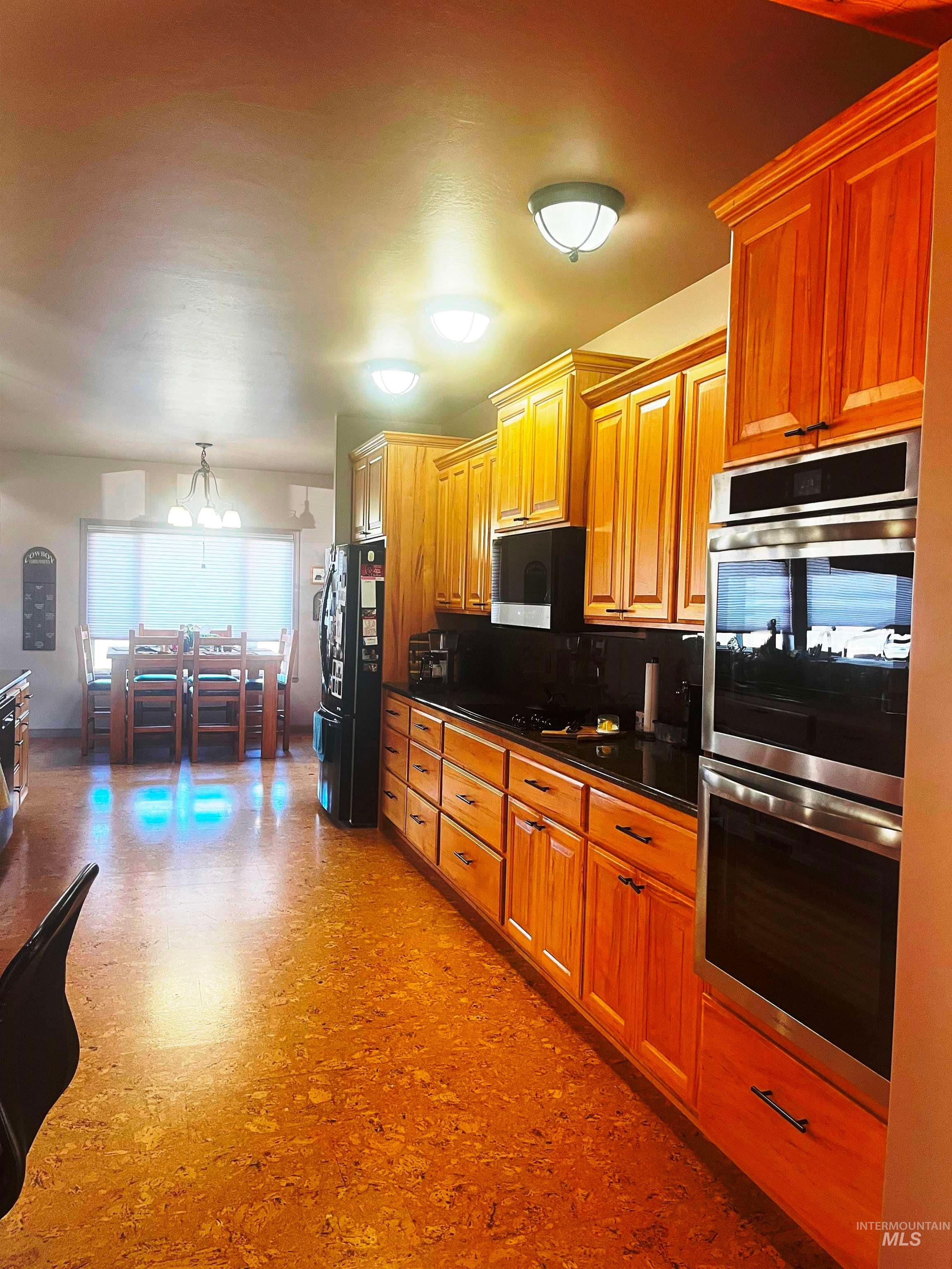 Kitchen with brown cabinetry and stainless steel cooktop