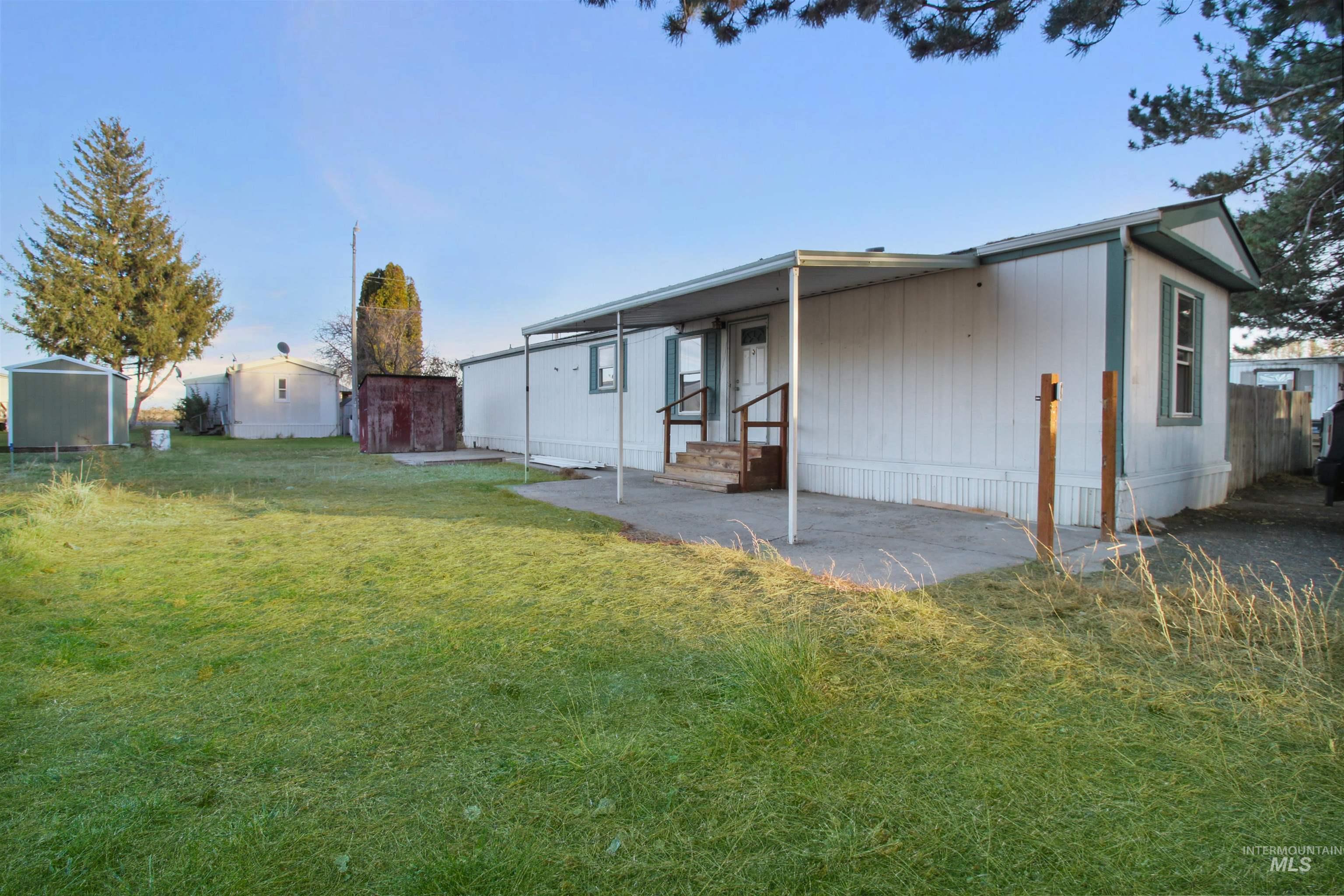 Back of house with a lawn, a patio, and entry steps