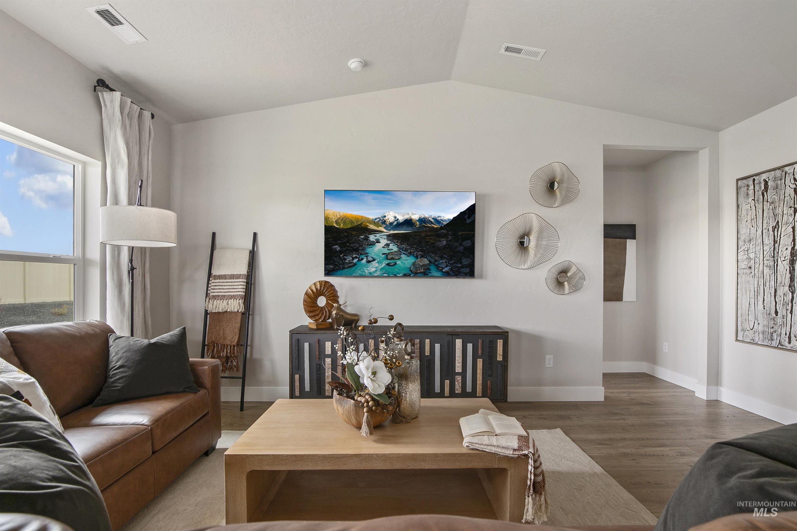 Living room with wood finished floors and vaulted ceiling