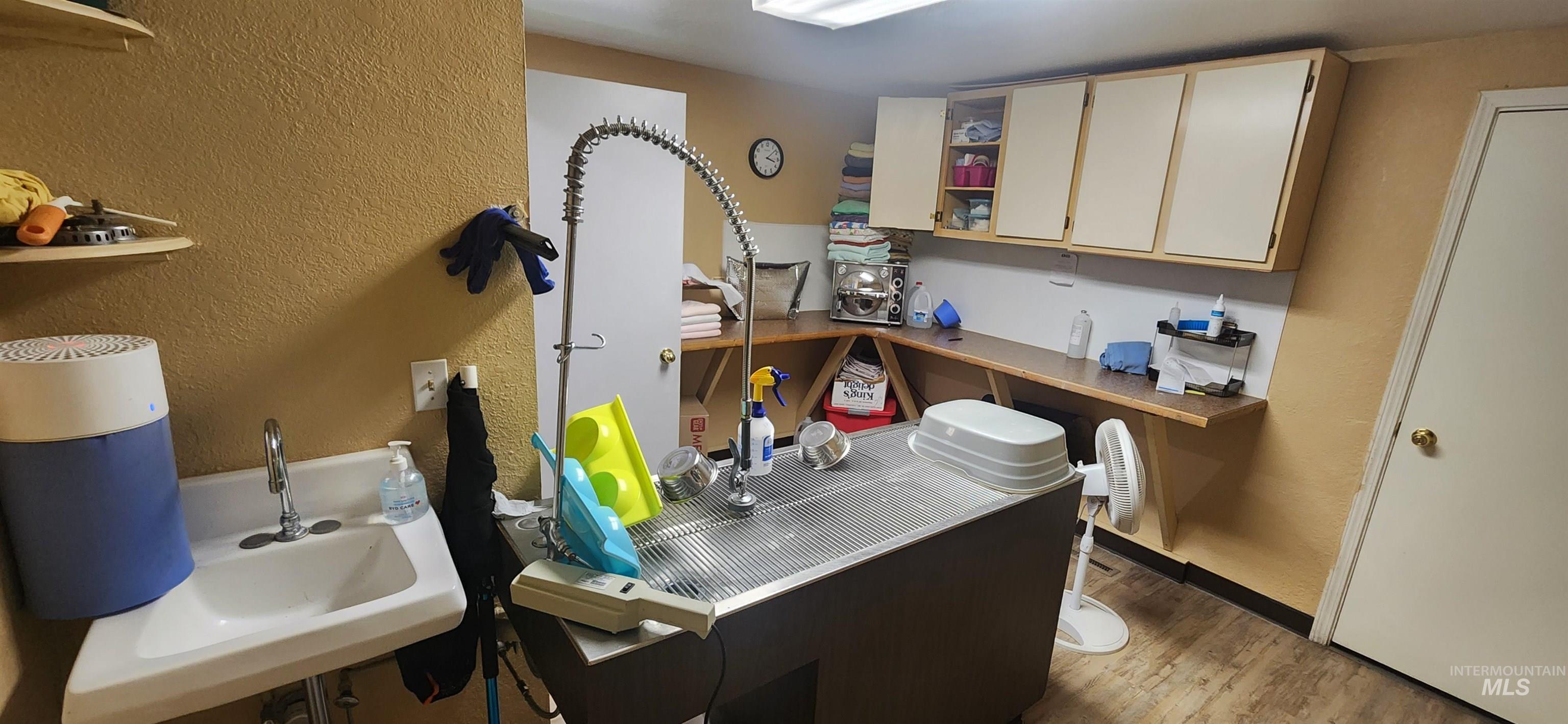 Kitchen featuring a textured wall, open shelves, and light wood-style flooring