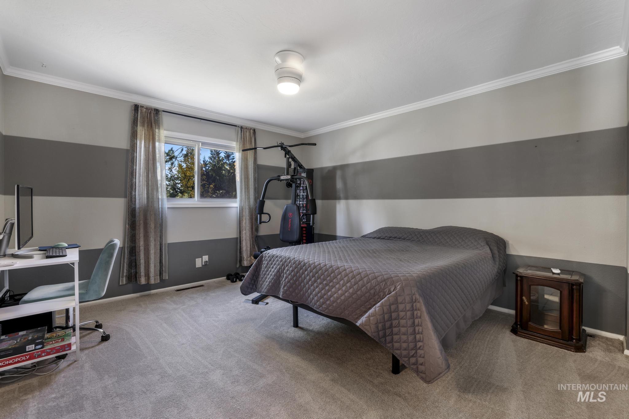 Bedroom with crown molding, carpet floors, and an office area