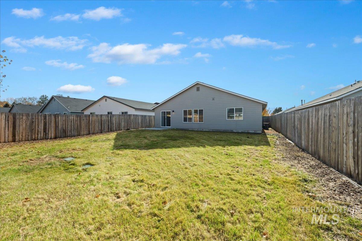 Rear view of property featuring a fenced backyard and a patio