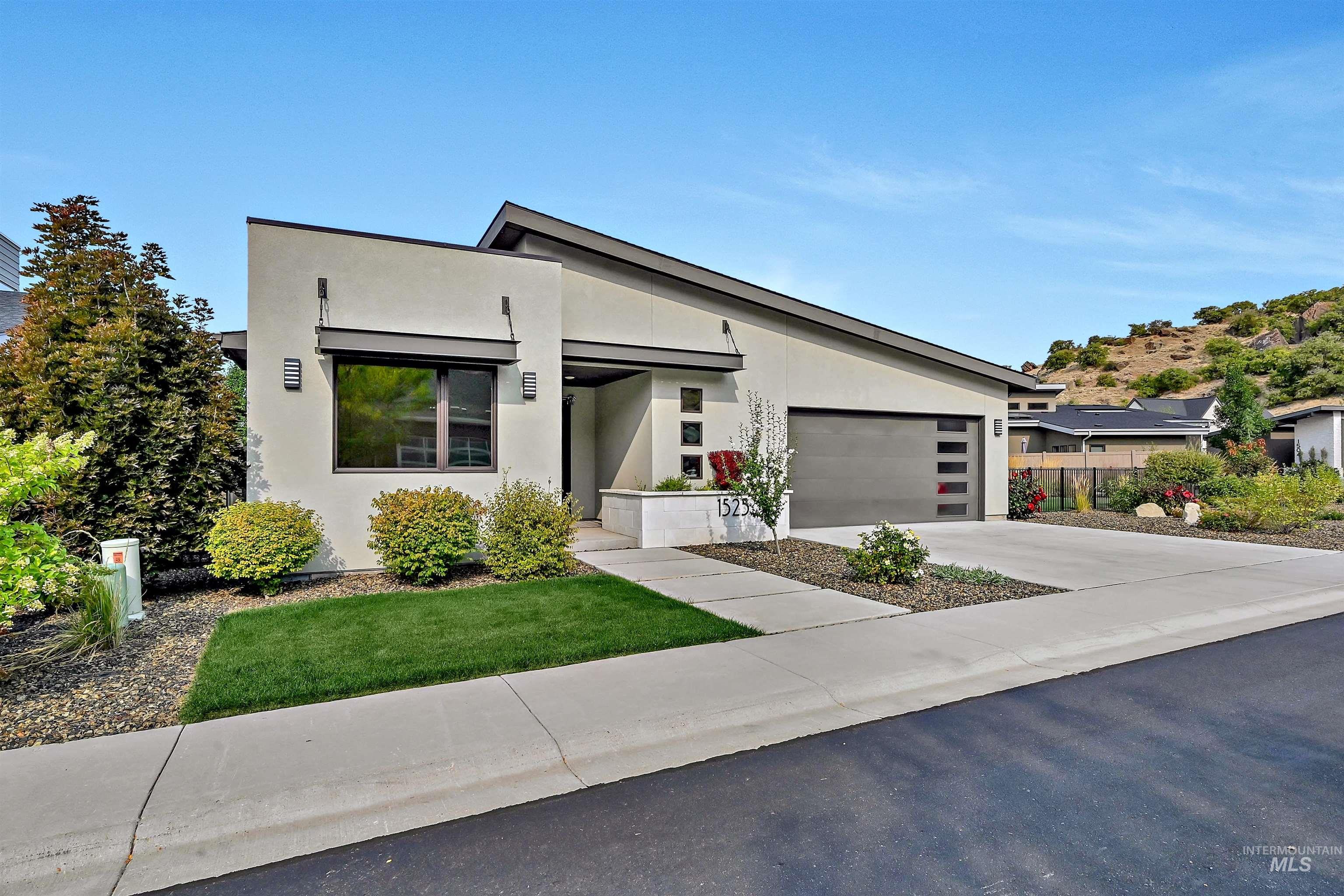 Contemporary house with stucco siding, concrete driveway, and an attached garage