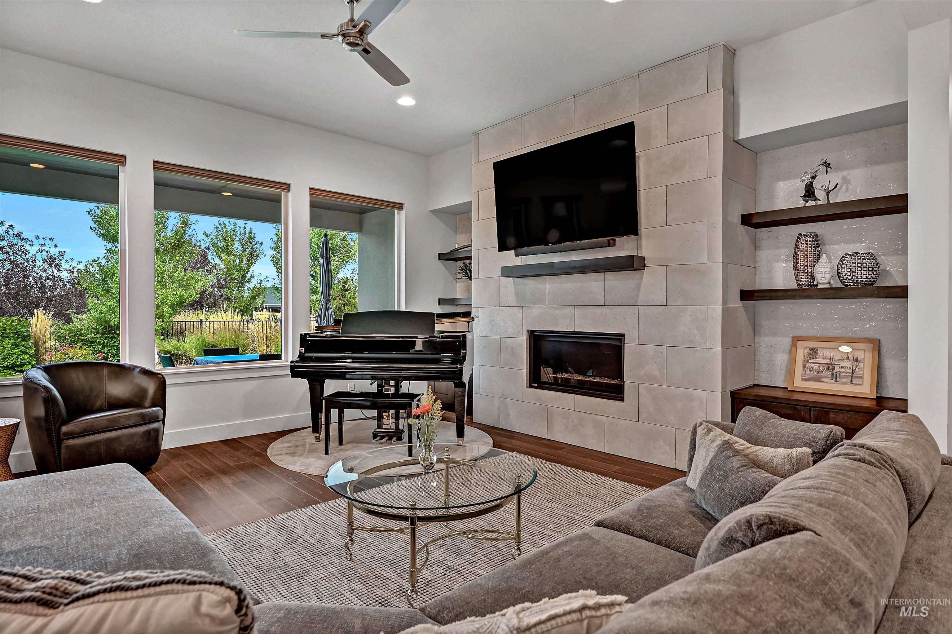 Living room featuring a tile fireplace, wood finished floors, recessed lighting, and a ceiling fan