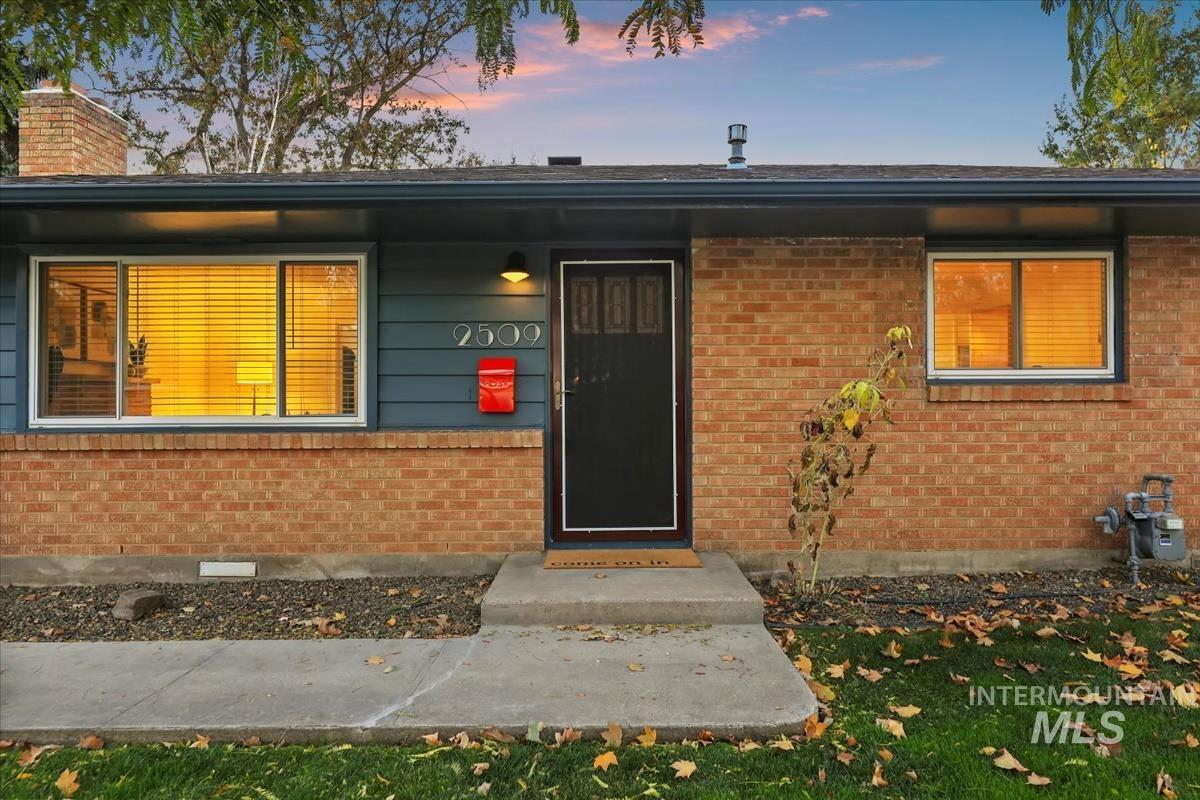 Entrance to property with brick siding and a chimney