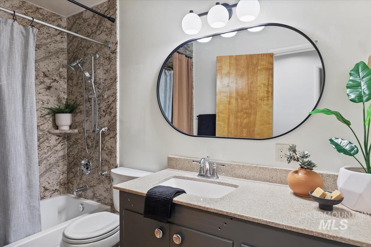 Bathroom featuring shower / bath combo with shower curtain and vanity